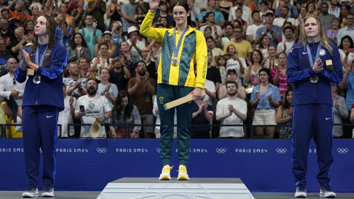 CAPTION CORRECTS SPELLING Gold medalist Australia's Kaylee McKeown, centre, stands with silver medalist, Regan Smith of the United States, left, and bronze medalist Katharine Berkoff of the United States on the podium following women's 100-meter backstroke final at the 2024 Summer Olympics, Monday, Tuesday, July 30, 2024.