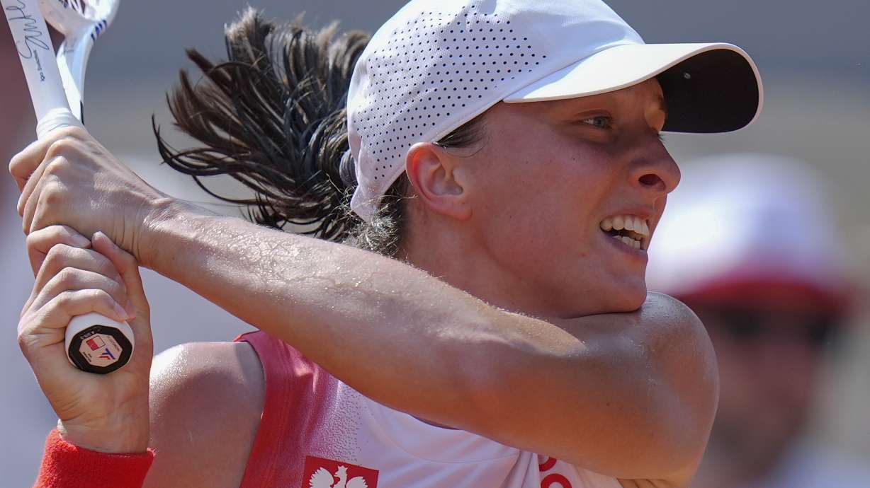 Iga Swiatek of Poland returns a shot to Anna Karolina Schmiedlova of Slovakia during their women's bronze medal match, at the 2024 Summer Olympics, Friday, Aug. 2, 2024, at the Roland Garros stadium in Paris, France.