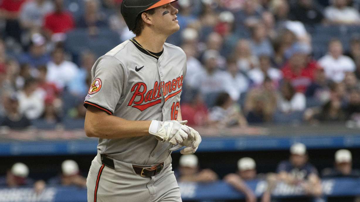 Baltimore Orioles' Coby Mayo heads to first base with a walk by Cleveland Guardians starting pitcher Carlos Carrasco during the second inning of a baseball game in Cleveland, Friday, Aug. 2, 2024. It was Mayo's first major league at-bat.