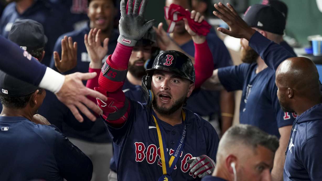 Boston Red Sox's Wilyer Abreu, center, is congratulated in the dugout after hitting a two-run home run during the second inning of a baseball game against the Texas Rangers, Friday, Aug. 2, 2024, in Arlington, Texas.