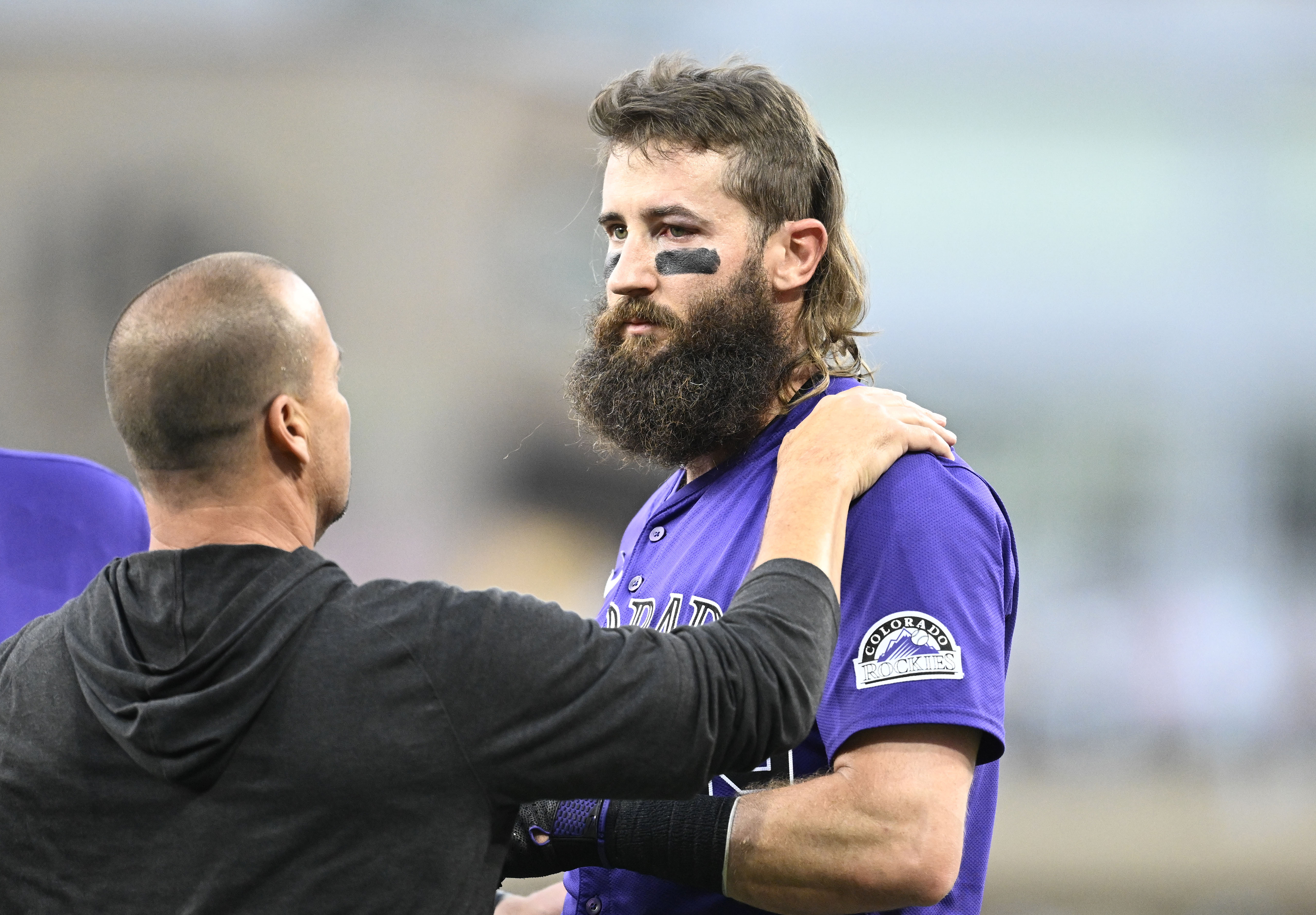 An unidentified trainer, left, looks at Colorado Rockies' Charlie Blackmon, right, after Blackmon was hit with a throw during the third inning of a baseball game against the San Diego Padres, Friday, Aug. 2, 2024, in San Diego. 