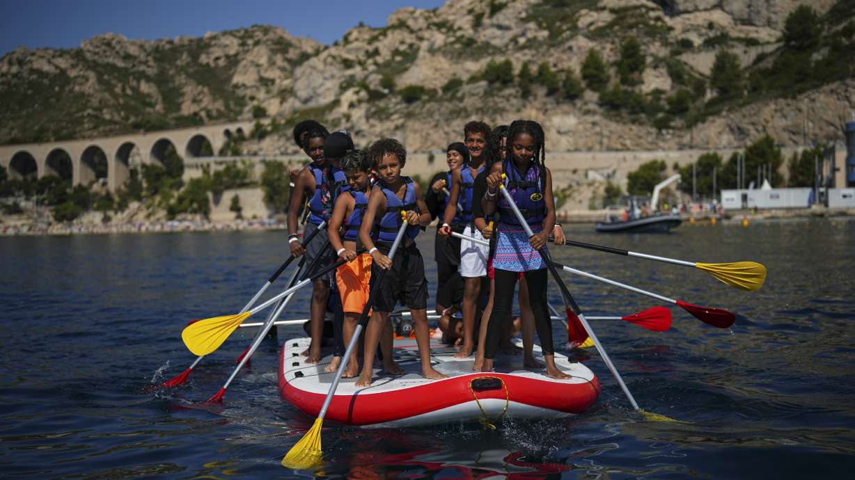 Children attend a swimming camp organized by the Grand Bleu Association which facilitates access to the sea for marginalized children in Marseille, France, Friday, July 26, 2024. Marseille, a millennia-old port, is a crossroads of cultures and faiths, where the sea is ever present but not equally accessible, and the beauty and cosmopolitan flair rub shoulders with enclaves of poverty and exclusion even more intimately than in the rest of France.