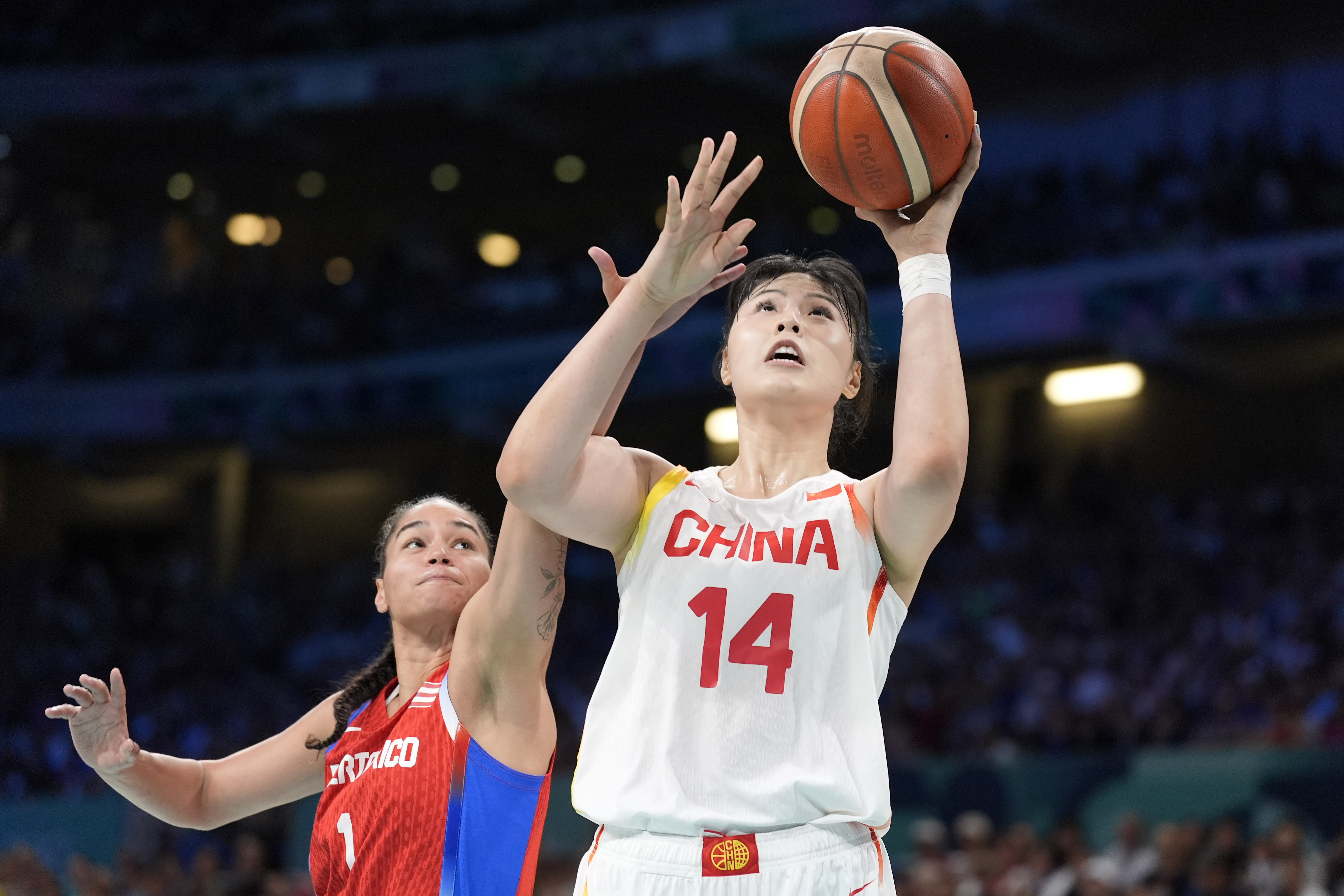 China's Li Yueru, right, shoots as Puerto Rico's Tayra Melendez defends during a women's basketball game at the 2024 Summer Olympics, Saturday, Aug. 3, 2024, in Villeneuve-d'Ascq, France.