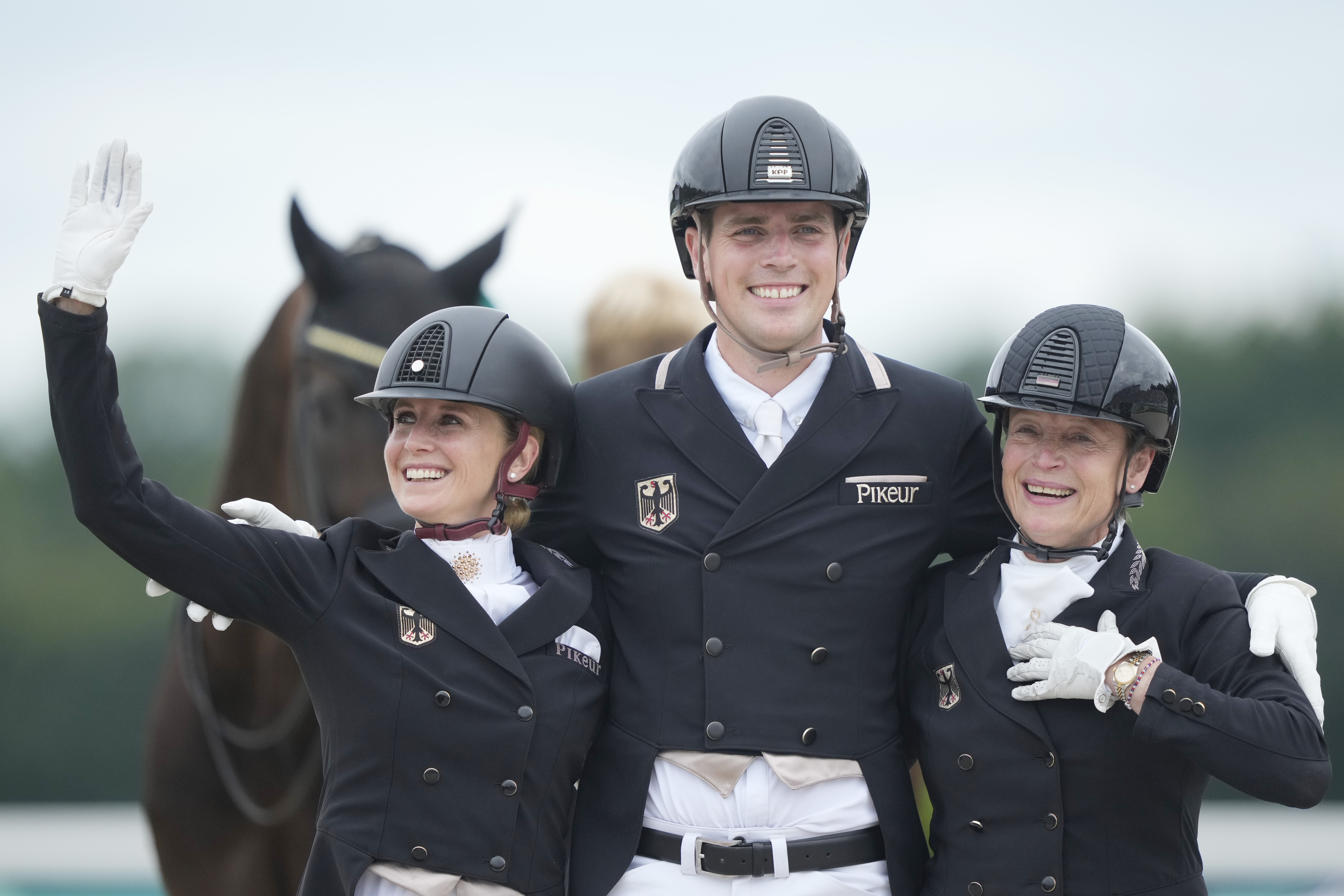 Team Germany, from left to right, Jessica von Bredow-Werndl, Frederic Wandres and Isabell Werth, celebrate their gold medals at the dressage team Grand Prix final, at the 2024 Summer Olympics, Saturday, Aug. 3, 2024, in Versailles, France. 