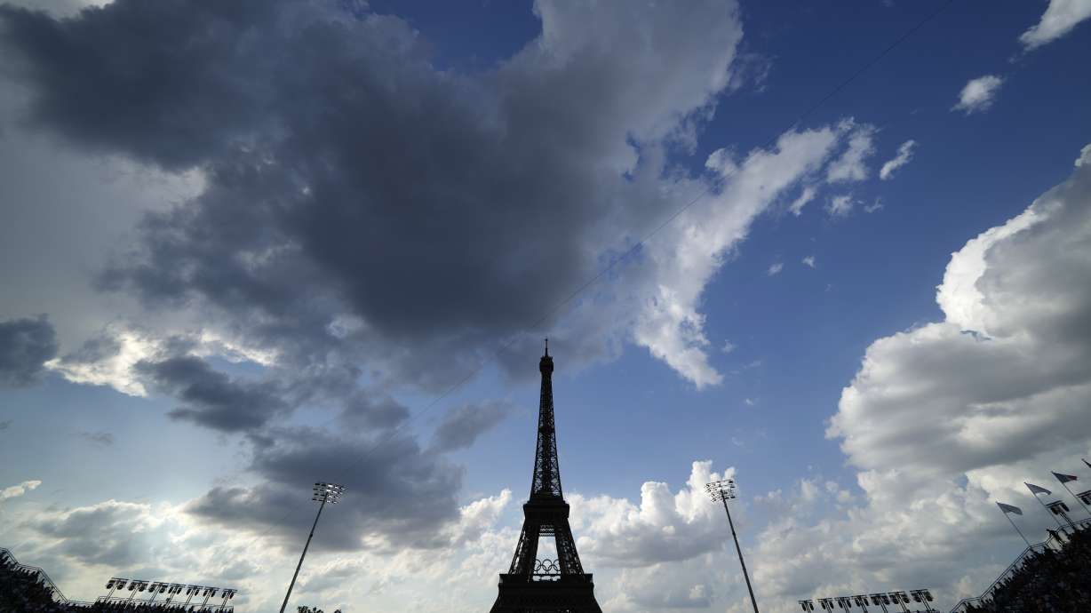 The Eiffel Tower looms over the beach volleyball venue during a match between Italy and Sweden at the 2024 Summer Olympics, Thursday, Aug. 1, 2024, in Paris, France.
