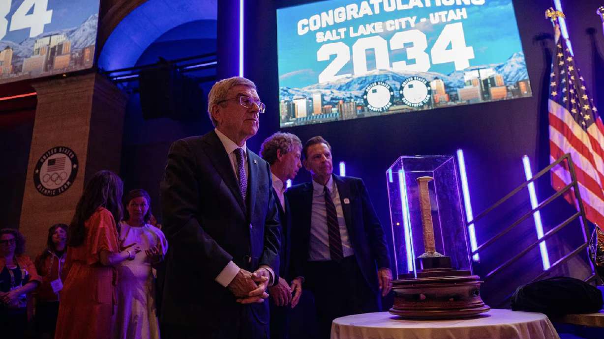 From right, Salt Lake City-Utah Committee for the Games CEO Fraser Bullock and the bid's chair of the cultural Olympiad, Steve Price, stand beside a smaller replica of the massive Golden Spike Monument gifted to IOC President Thomas Bach July 24, in Paris.