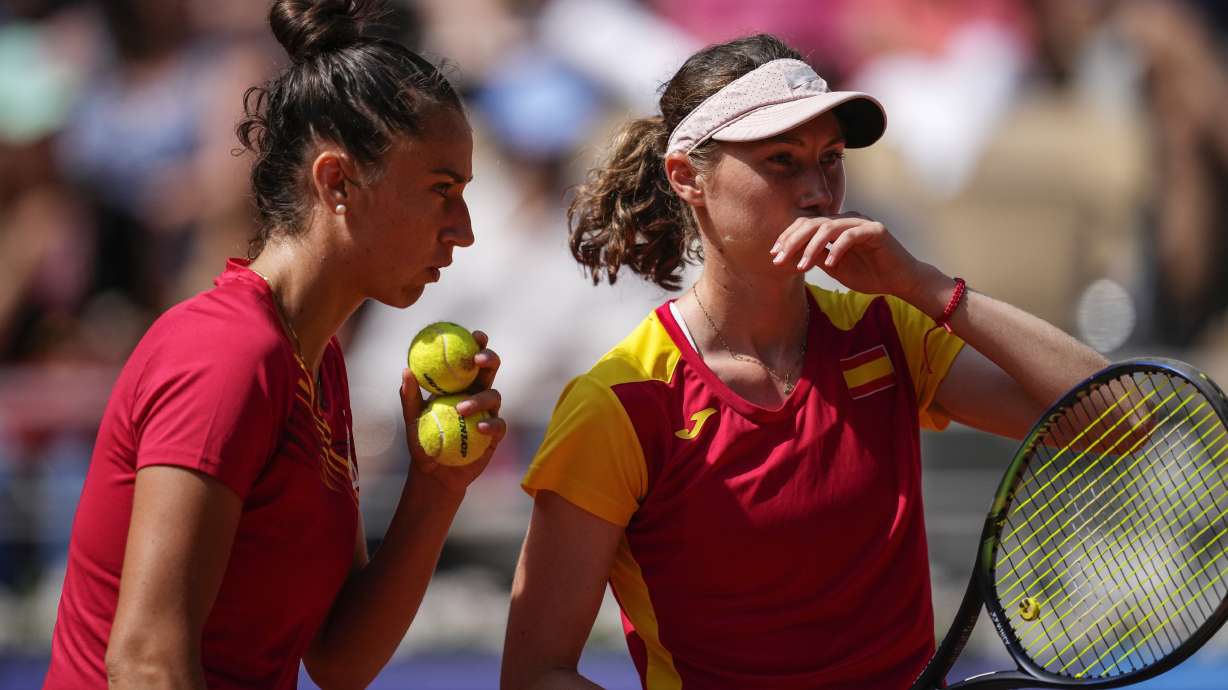 Cristina Bucsa and Sara Sorribes Tormo of Spain talk as they play against Linda Noskova and Karolina Muchova of the Czech Republic during their women's doubles bronze medal tennis match at the Roland Garros stadium, at the 2024 Summer Olympics, Sunday, Aug. 4, 2024, in Paris, France.
