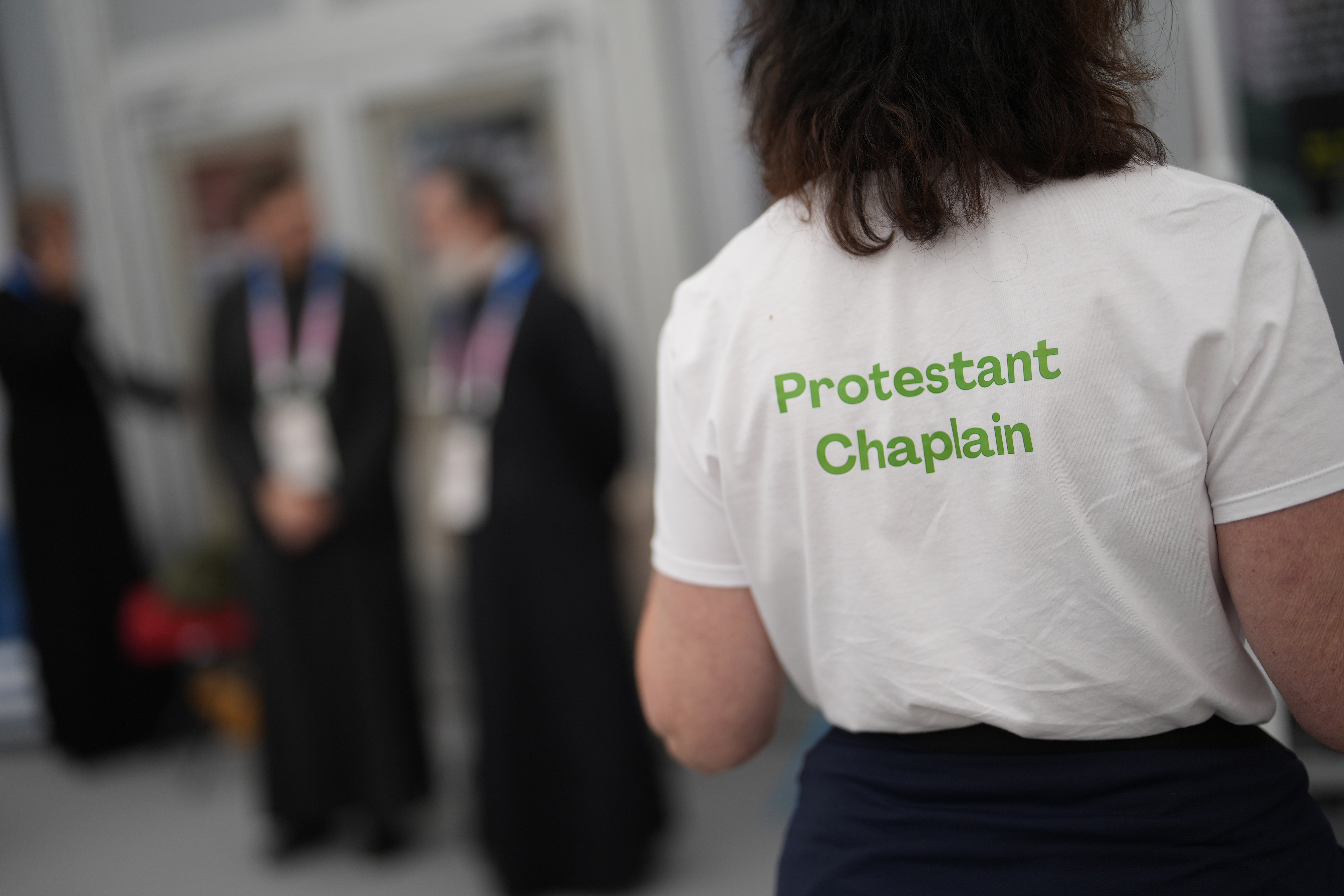 A woman wears a t-shirt to help distinguish religions in the religious area of the Olympic Village at the 2024 Summer Olympics, Tuesday, July 23, 2024, in Paris, France. 