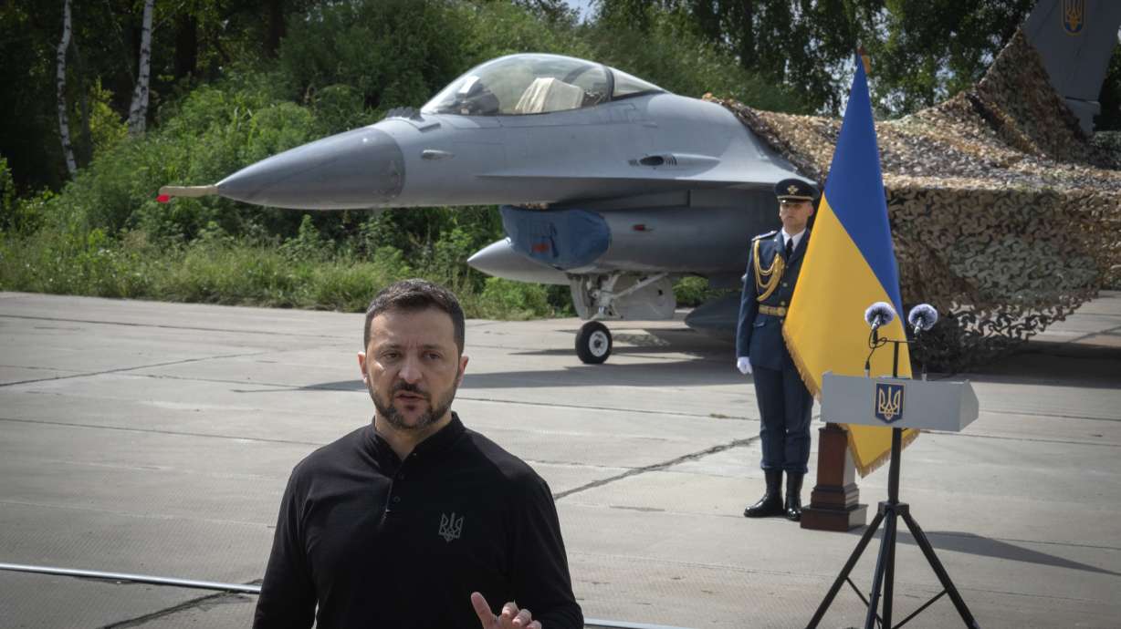 Ukraine's President Volodymyr Zelenskyy answers media questions standing against the background of Ukraine's Air Force's F-16 fighter jets in an undisclosed location in Ukraine, Sunday. The F-16 fighter jets have been delivered to Ukraine by Western countries.