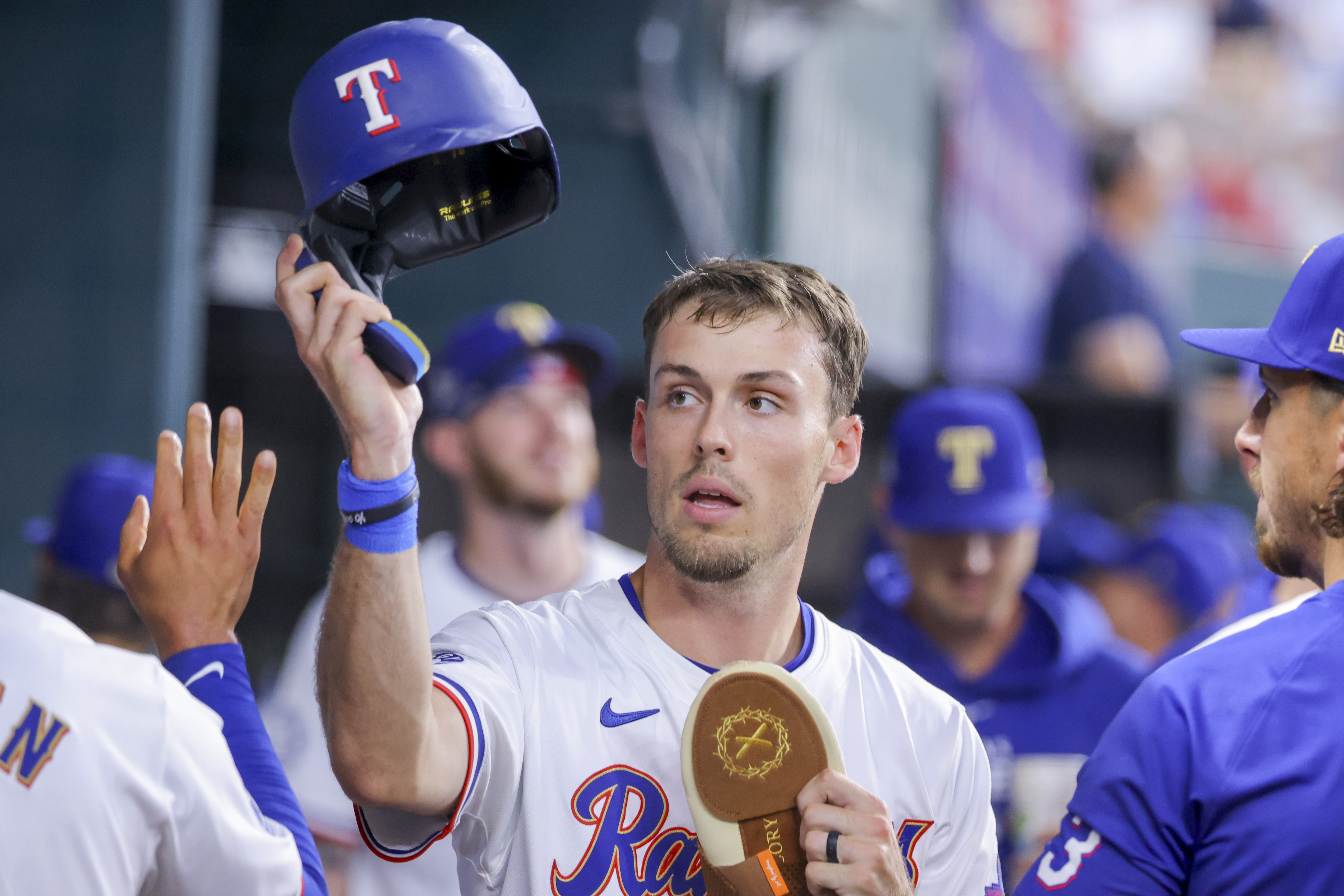 FILE - Texas Rangers' Evan Carter celebrates in the dugout during a game against the Chicago Cubs, March 31, 2024, in Arlington, Texas. Carter is unlikely to return in what was supposed to be the outfielder's first full season in the majors due to a nagging back injury general manager Chris Young said Tuesday, July 30, 2024.