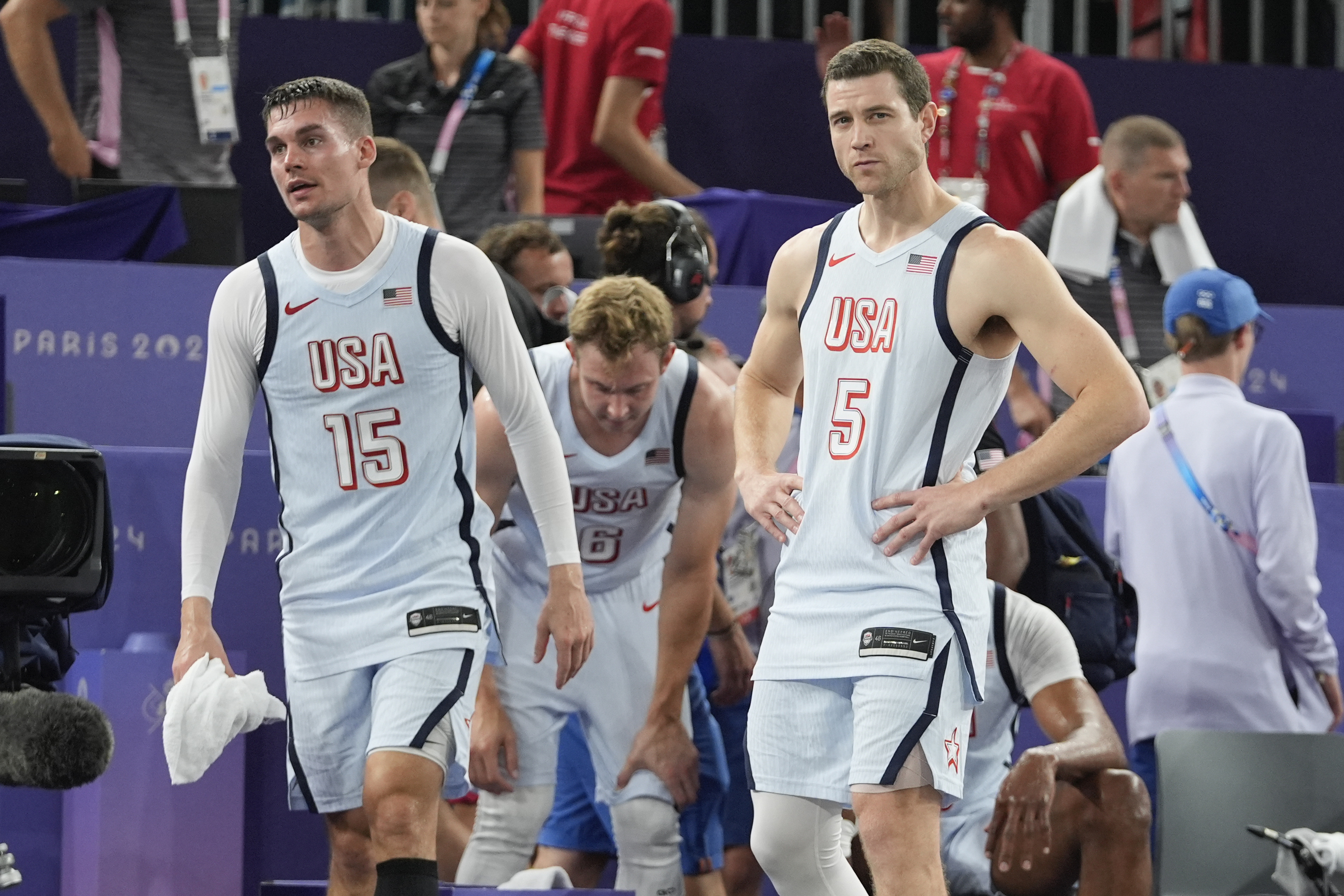 Dylan Travis (15), of the United States, Jimmer Fredette (5) and Canyon Barry (6) react after a men's 3x3 basketball pool round match against Latvia during the 2024 Summer Olympics, Friday, Aug. 2, 2024, in Paris, France. Serbia won 19-16. Latvia won 21-19. 