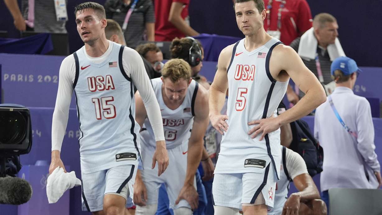 Dylan Travis (15), of the United States, Jimmer Fredette (5) and Canyon Barry (6) react after a men's 3x3 basketball pool round match against Latvia during the 2024 Summer Olympics, Friday, Aug. 2, 2024, in Paris, France. Serbia won 19-16. Latvia won 21-19.