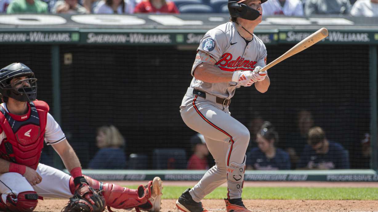 Baltimore Orioles' Jackson Holliday, right, watches his solo home run off Cleveland Guardians starting pitcher Gavin Williams as Guardians catcher Austin Hedges, left, also watches during the fourth inning of a baseball game in Cleveland, Sunday, Aug. 4, 2024.