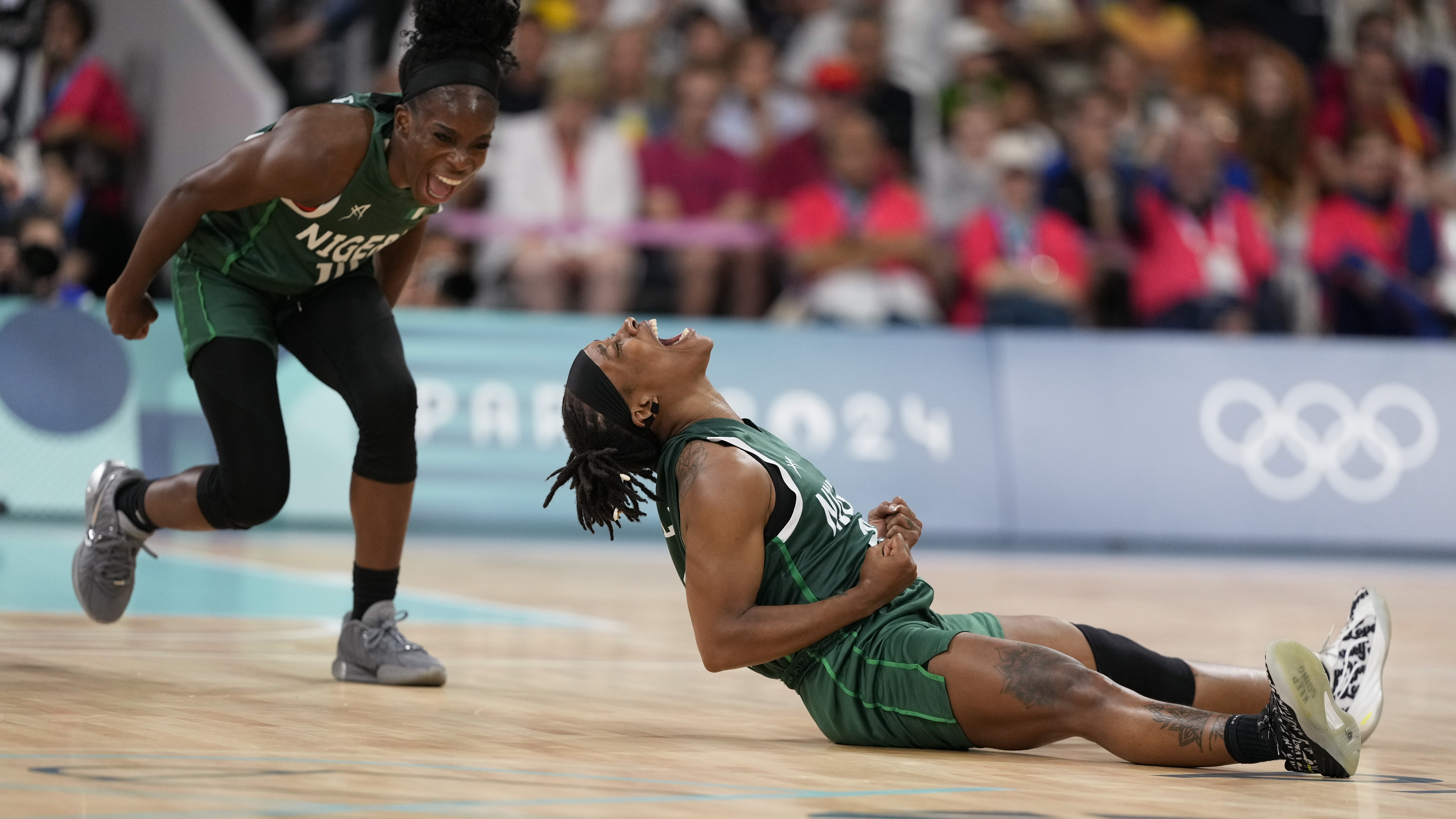 Ezinne Kalu (23), and Promise Amukamara (10), of Nigeria, celebrate in a women's basketball game against Canada at the 2024 Summer Olympics, Sunday, Aug. 4, 2024, in Villeneuve-d'Ascq, France. 