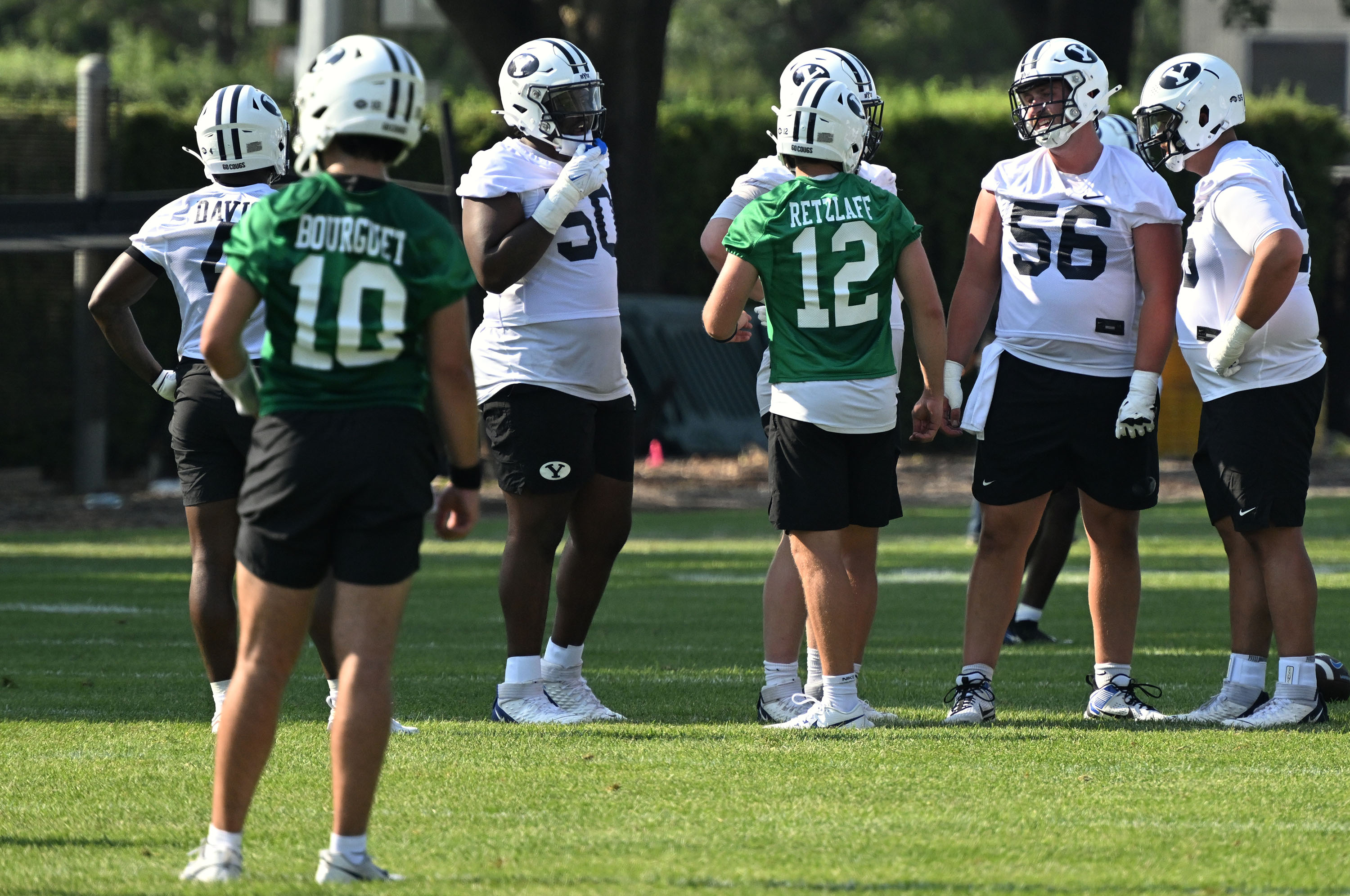 BYU quarterback Treyson Bourguet (10) watches as quarterback Jake Retzlaff (12) talks with the linemen as BYU holds their first fall football practice in Provo on Wednesday, July 31, 2024.