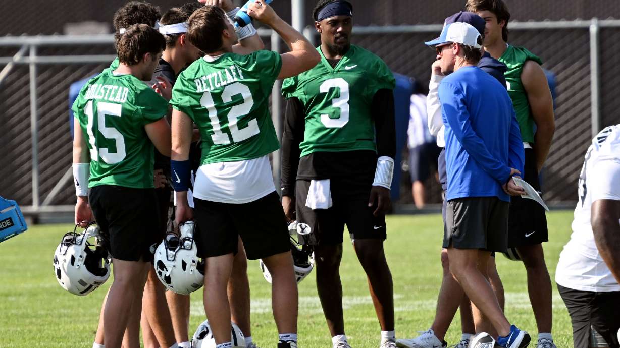 Quarterbacks huddle with coach Aaron Roderick and others as BYU completes their first fall football practice in Provo on Wednesday, July 31, 2024.