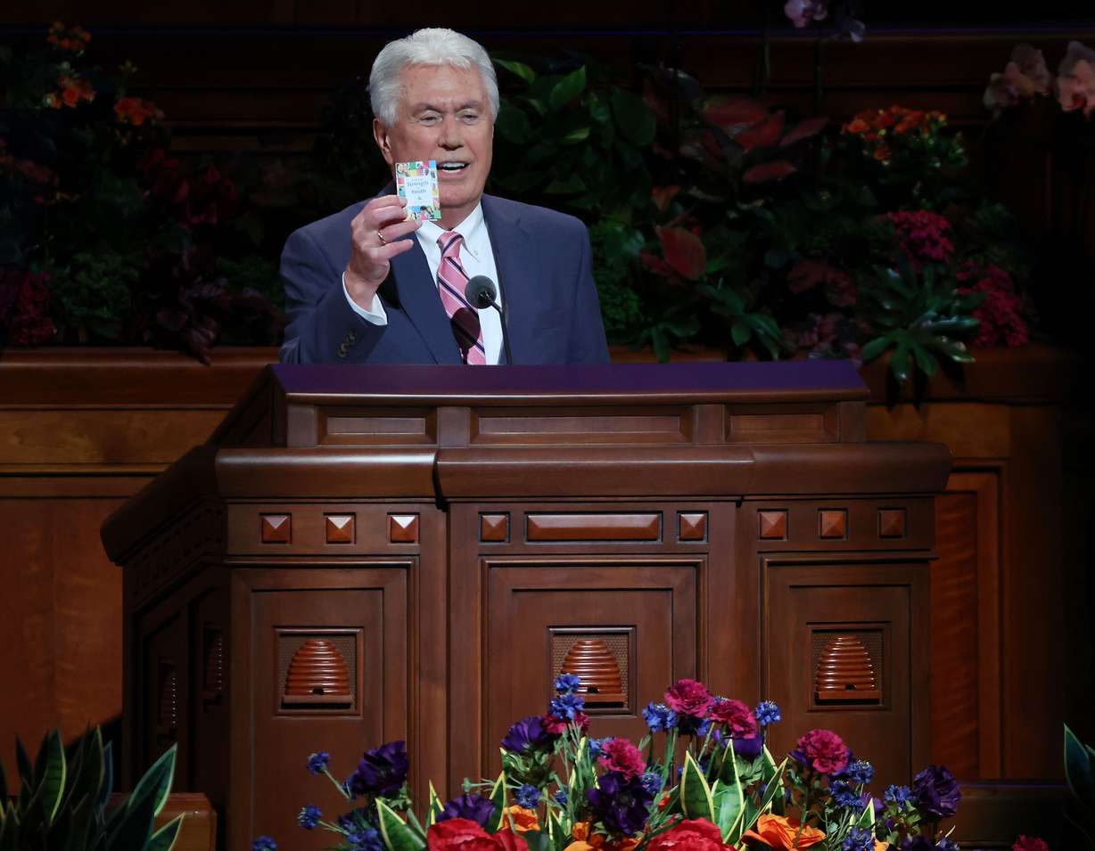 Elder Dieter F. Uchtdorf of the Quorum of the Twelve Apostles of The Church of Jesus Christ of Latter-day Saints, holds a For the Strength of Youth pamphlet while speaking during the YSA Conference devotional at the Conference Center in Salt Lake City on Sunday.