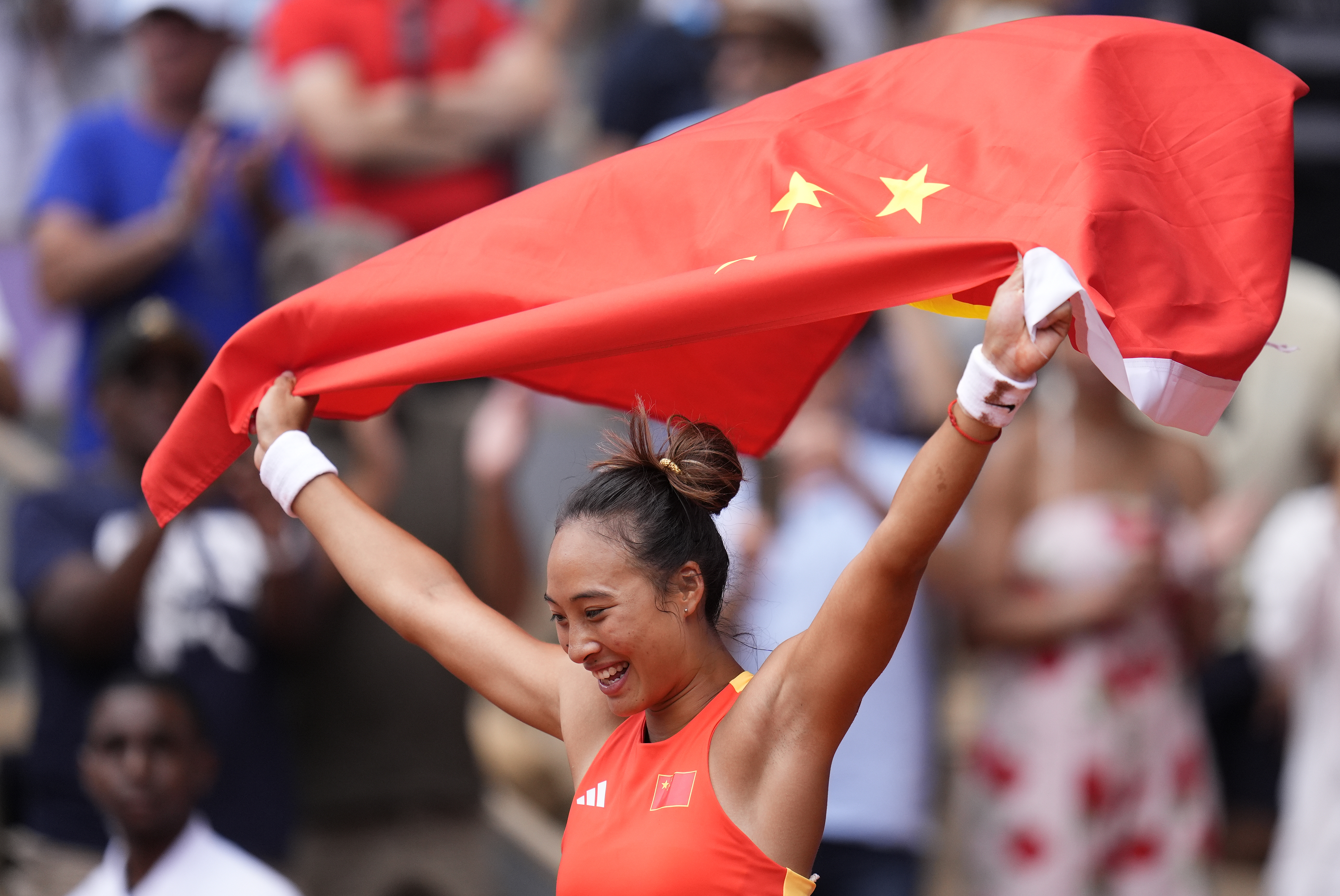 China's Zheng Qinwen holds a Chinese flag after defeating Croatia's Donna Vekic during the Women's Singles tennis final at the Roland Garros stadium at the 2024 Summer Olympics, Saturday, Aug. 3, 2024, in Paris, France. 