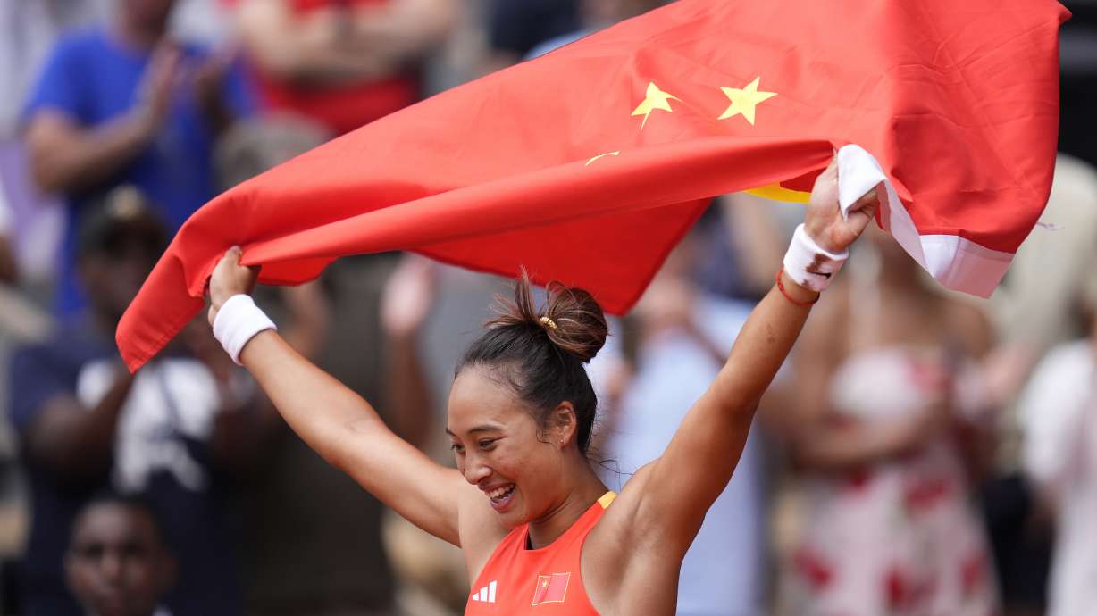 China's Zheng Qinwen holds a Chinese flag after defeating Croatia's Donna Vekic during the Women's Singles tennis final at the Roland Garros stadium at the 2024 Summer Olympics, Saturday, Aug. 3, 2024, in Paris, France.
