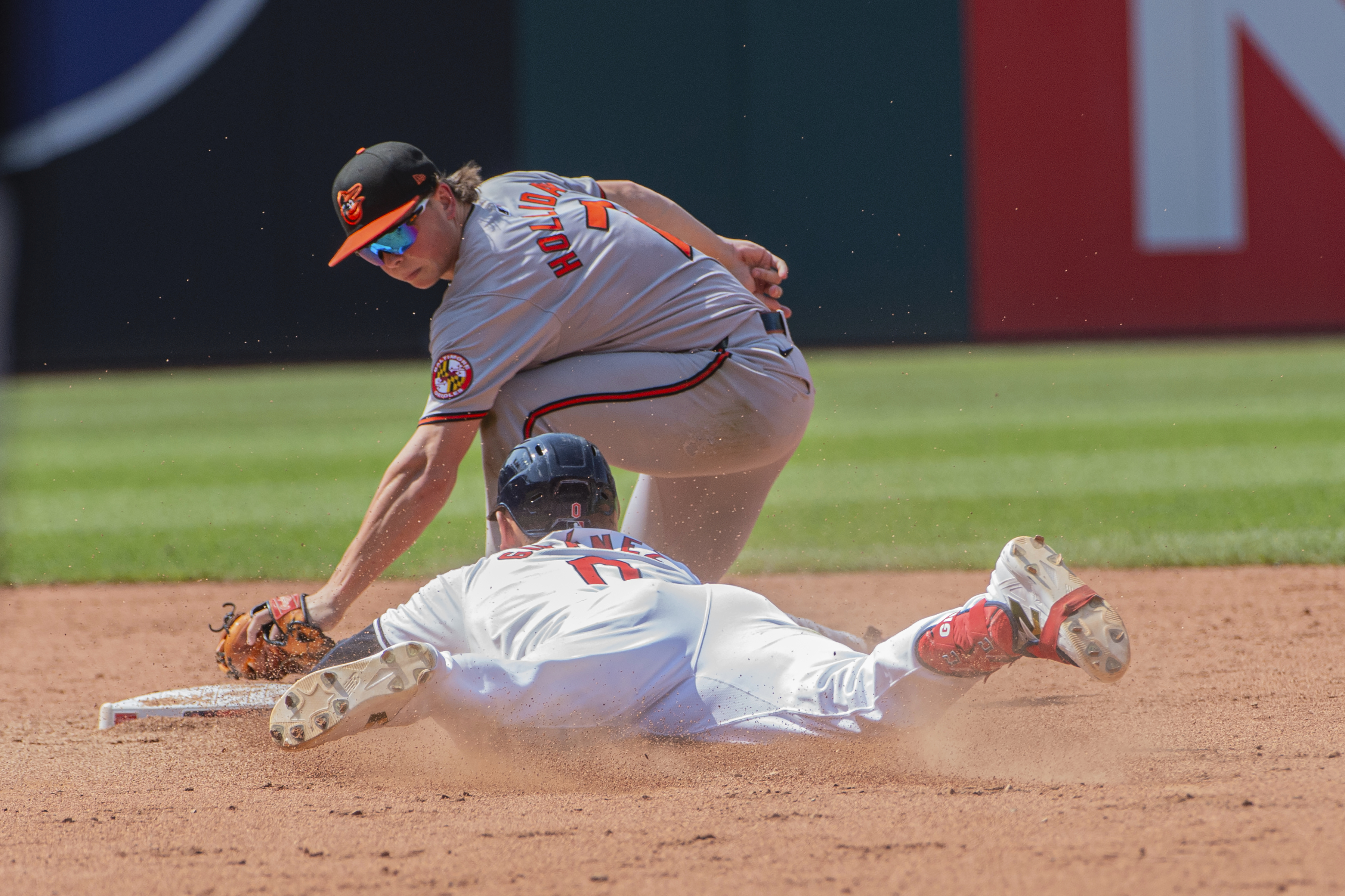 Baltimore Orioles' Jackson Holliday, top, tags out Cleveland Guardians' Andres Gimenez, bottom, at second base during the fifth inning of a baseball game in Cleveland, Sunday, Aug. 4, 2024. 