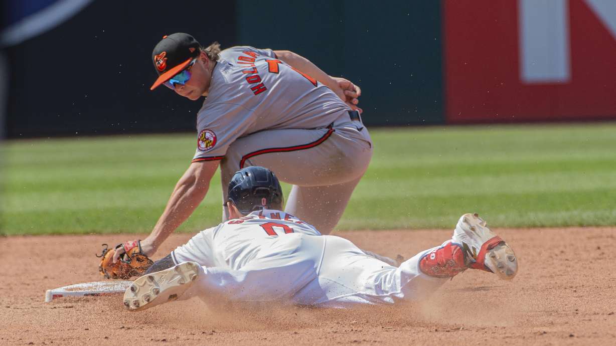 Baltimore Orioles' Jackson Holliday, top, tags out Cleveland Guardians' Andres Gimenez, bottom, at second base during the fifth inning of a baseball game in Cleveland, Sunday, Aug. 4, 2024.