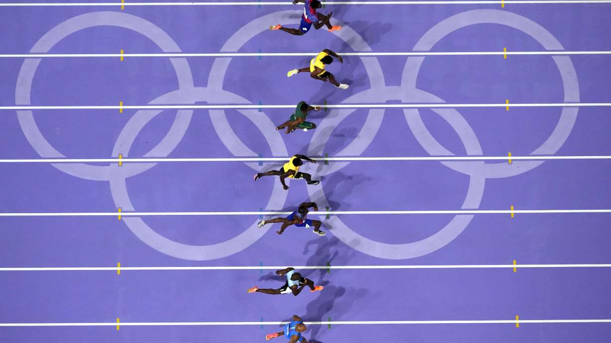 Noah Lyles (tercero desde abajo) corre rumbo a la victoria en la final de los 100 metros masculinos en los Juegos Olímpicos de París, el domingo 4 de agosto de 2024, en Saint-Denis, Francia.