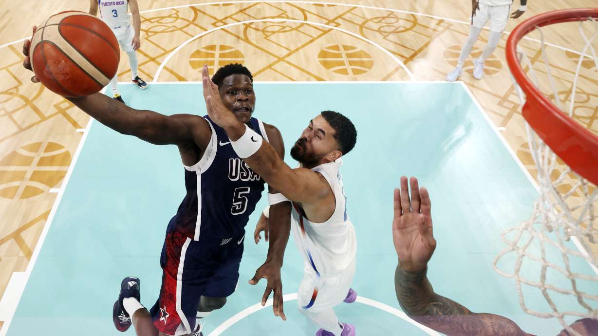 United States' Anthony Edwards, left, goes up for a shot as Puerto Rico's Arnaldo Toro defends at the 2024 Summer Olympics, Saturday, Aug. 3, 2024, in Villeneuve-d'Ascq, France.