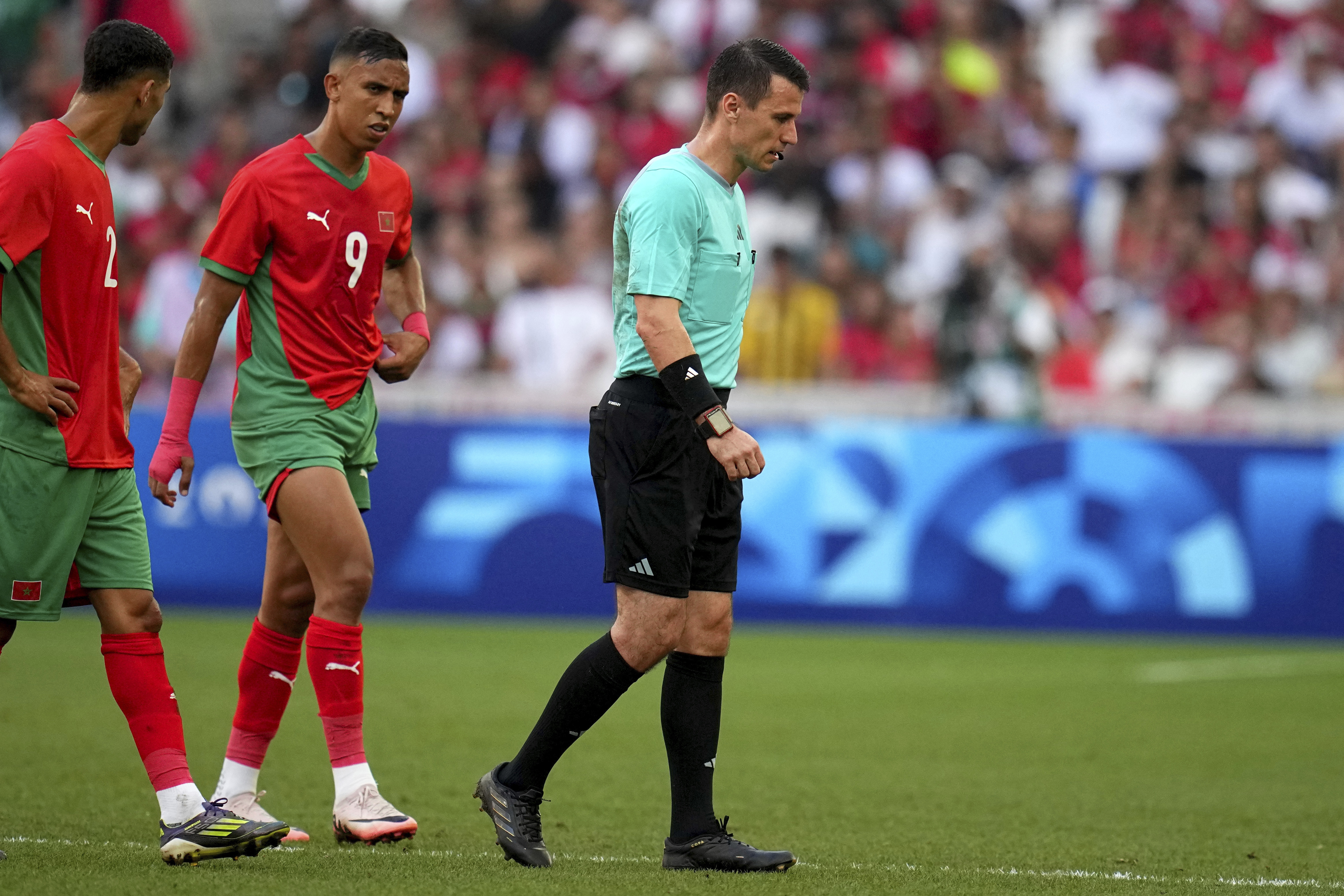 Referee Ilgiz Tantashev, of Uzbekistan, leaves the field after being injured during a men's semifinal soccer match between Morocco and Spain at the 2024 Summer Olympics, Monday, Aug. 5, 2024, at Marseille Stadium in Marseille, France. 