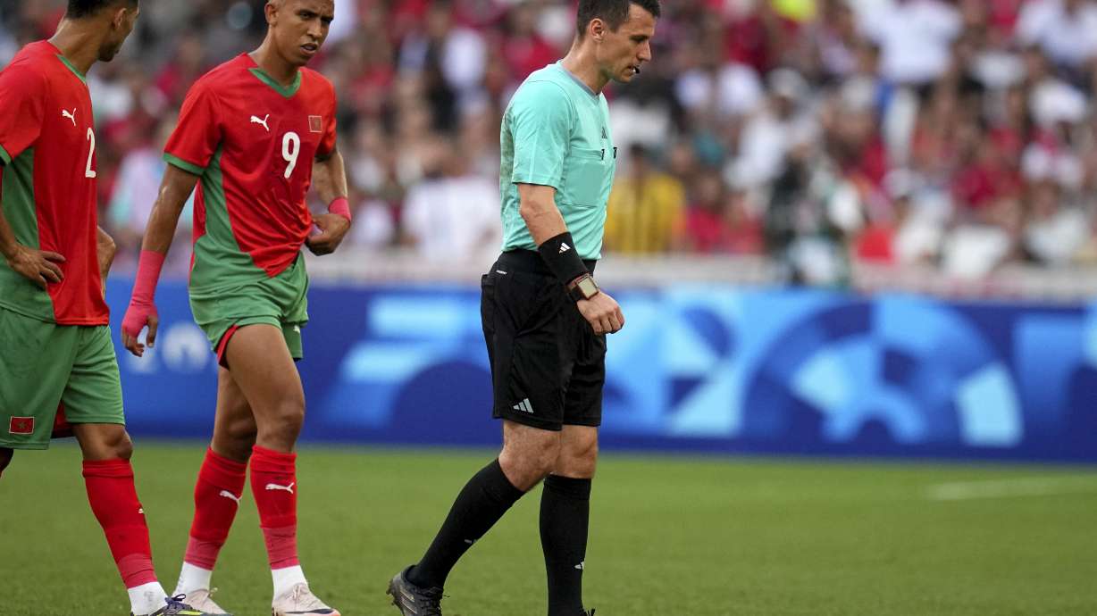 Referee Ilgiz Tantashev, of Uzbekistan, leaves the field after being injured during a men's semifinal soccer match between Morocco and Spain at the 2024 Summer Olympics, Monday, Aug. 5, 2024, at Marseille Stadium in Marseille, France.