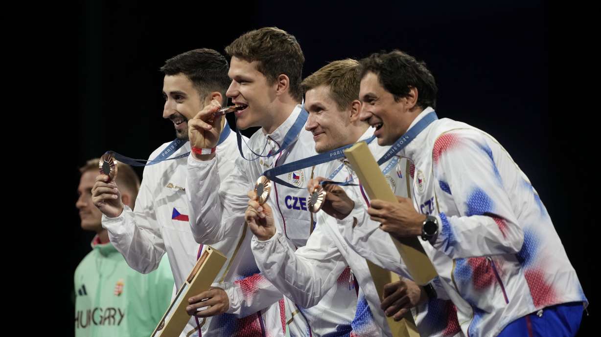 Czech Republic's fencers Jiri Beran, Jakub Jurka, Martin Rubes and Michal Cupr celebrate on the podium after winner the bronze medal in the men's team epee competition during the 2024 Summer Olympics at the Grand Palais, Friday, Aug. 2, 2024, in Paris, France.