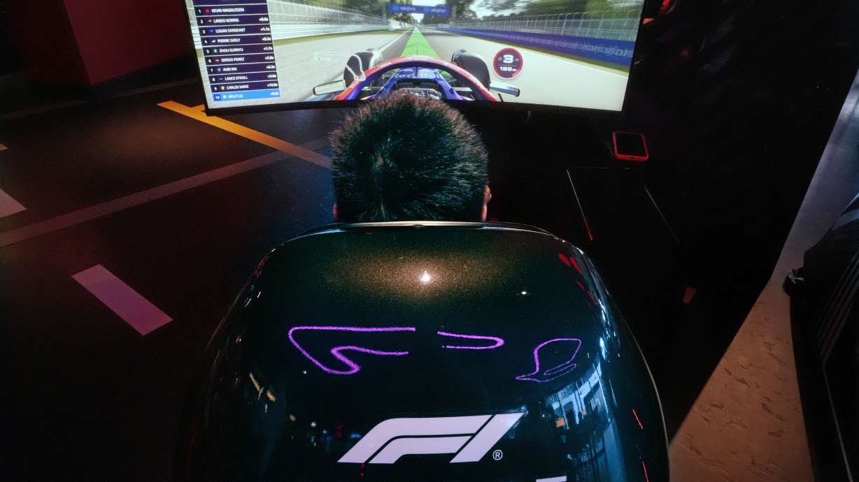 A video game driver races on a simulated track at the F1 Boston Arcade, Monday, July 8, 2024, in Boston.