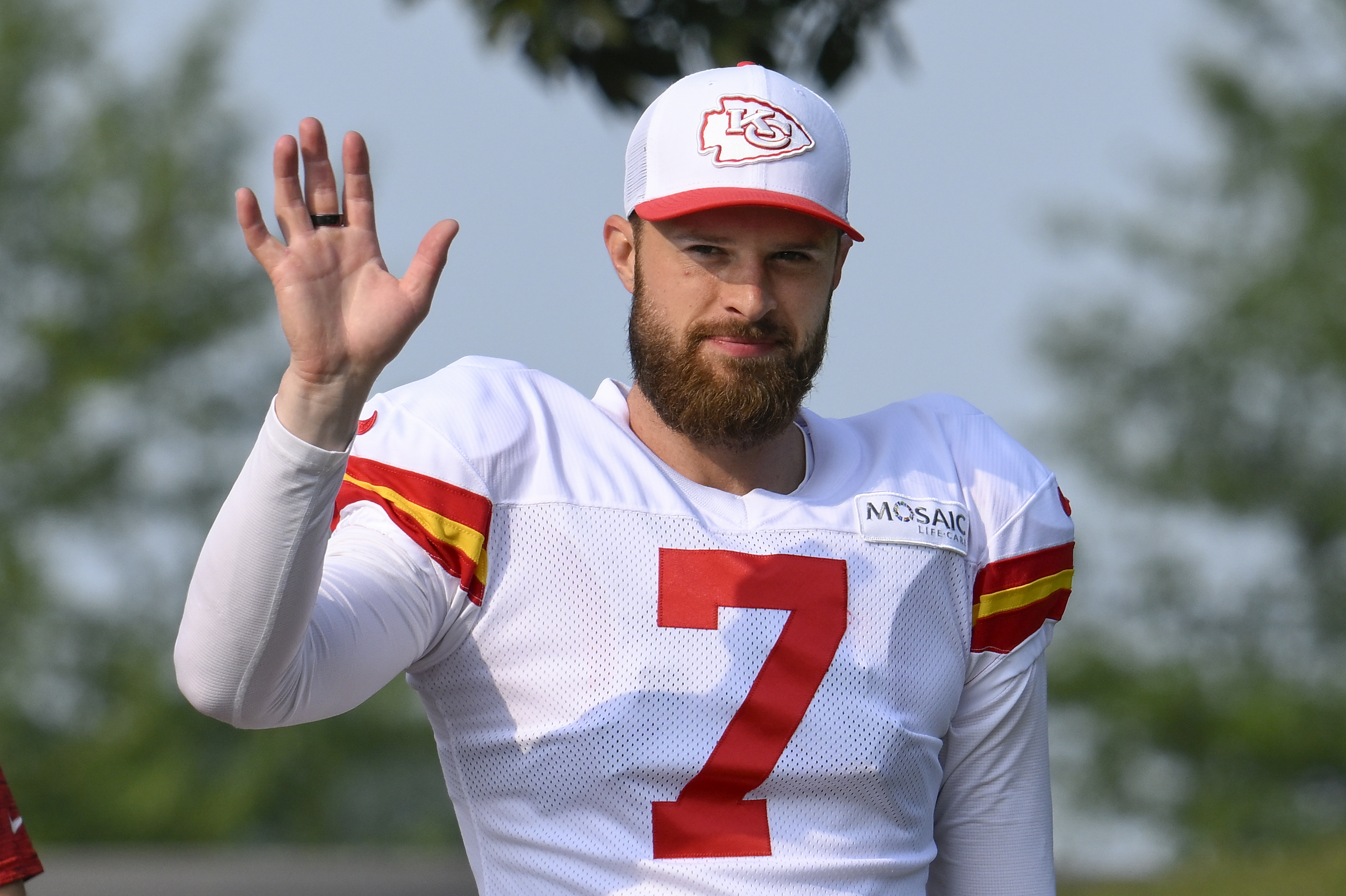 Kansas City Chiefs kicker Harrison Butker waves to the fans as he walks to the field at the start of an NFL football training camp Saturday, July 27, 2024, in St. Joseph, Mo. 