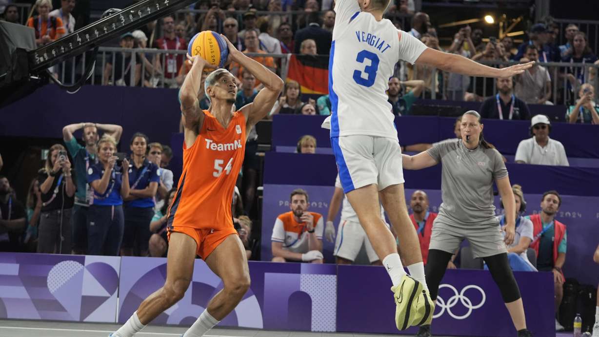 Worthy de Jong (54) of the Netherlands, shoots the game winning basket past Timothe Vergiat (3), of France, in overtime during a men's 3x3 basketball gold medal game during the 2024 Summer Olympics, Monday, Aug. 5, 2024, in Paris, France. Netherlands won 18-17.