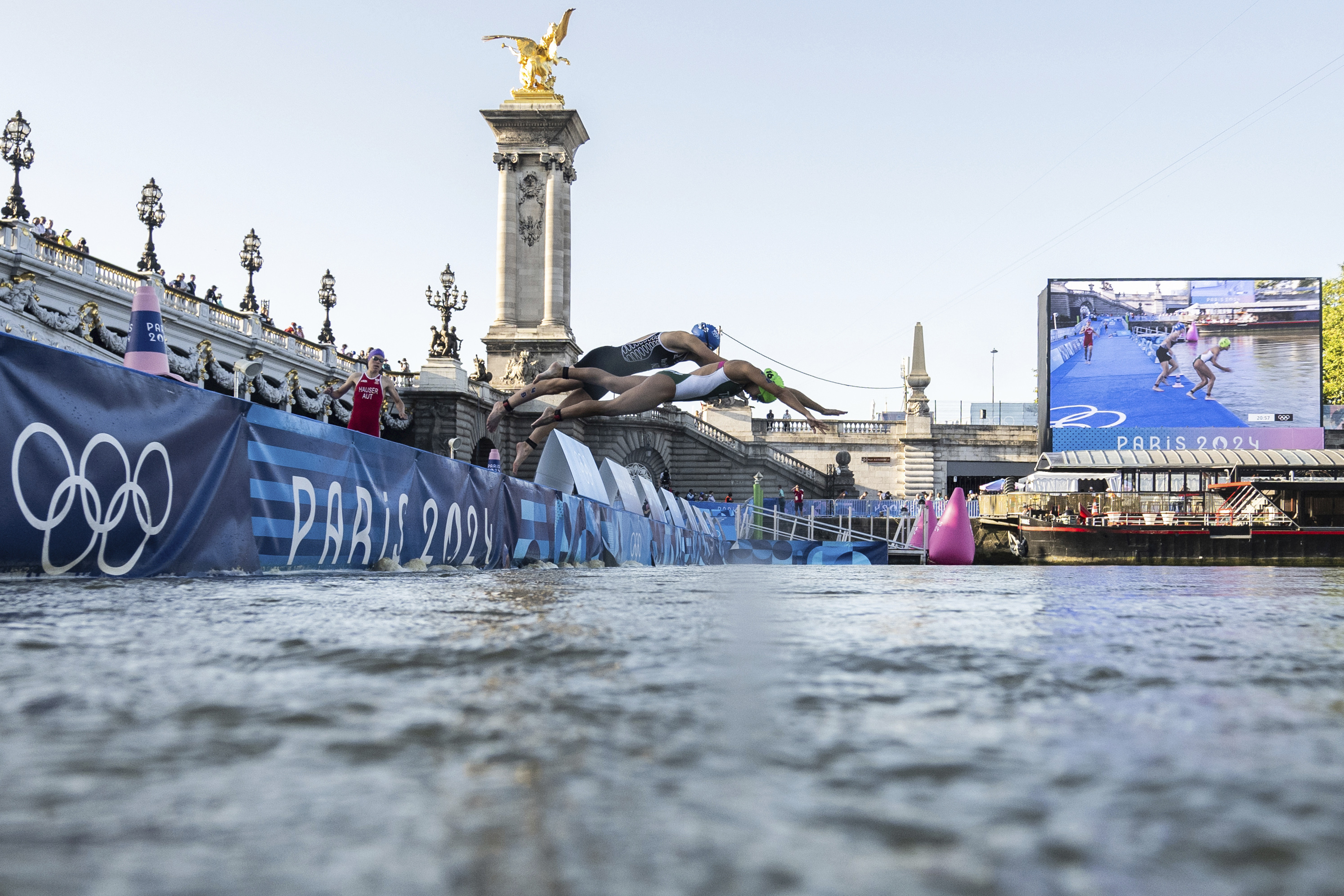 Athletes jump into the water to compete in the swimming race in the Seine river, during the mixed relay triathlon, at the 2024 Olympic Games, in Paris, France, Monday. On Tuesday, the marathon swim test was canceled due to water quality concerns.