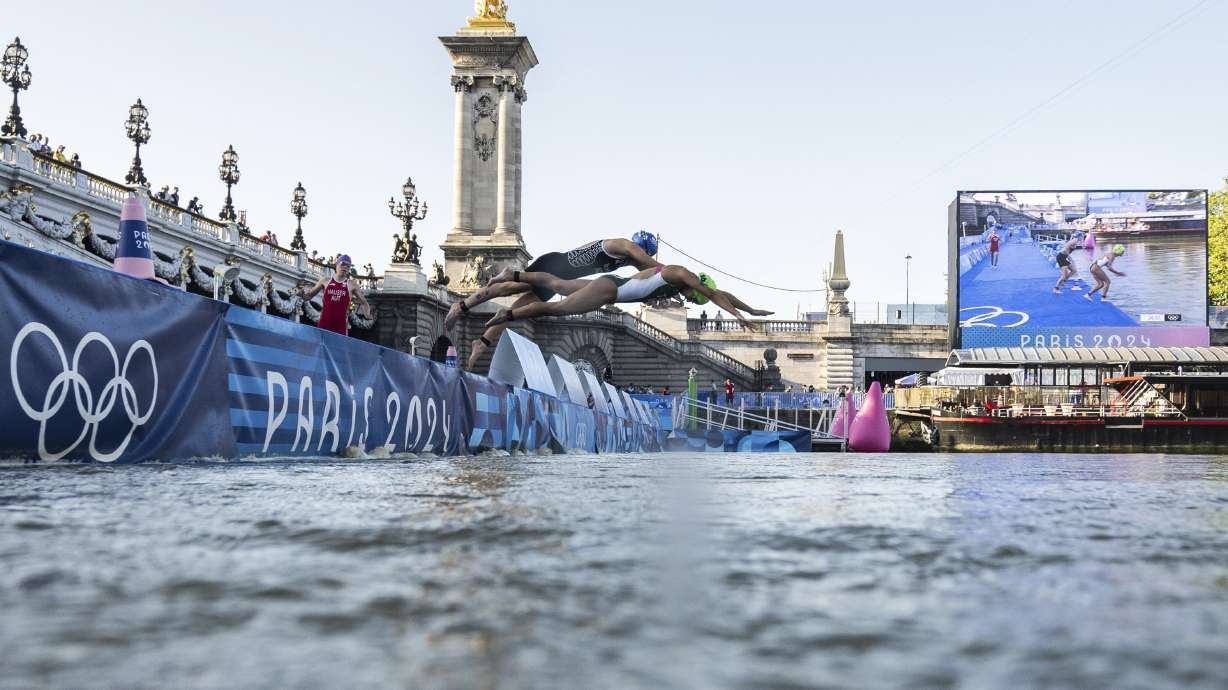 Athletes jump into the water to compete in the swimming race in the Seine river, during the mixed relay triathlon, at the 2024 Olympic Games, in Paris, France, Monday. On Tuesday, the marathon swim test was canceled due to water quality concerns.