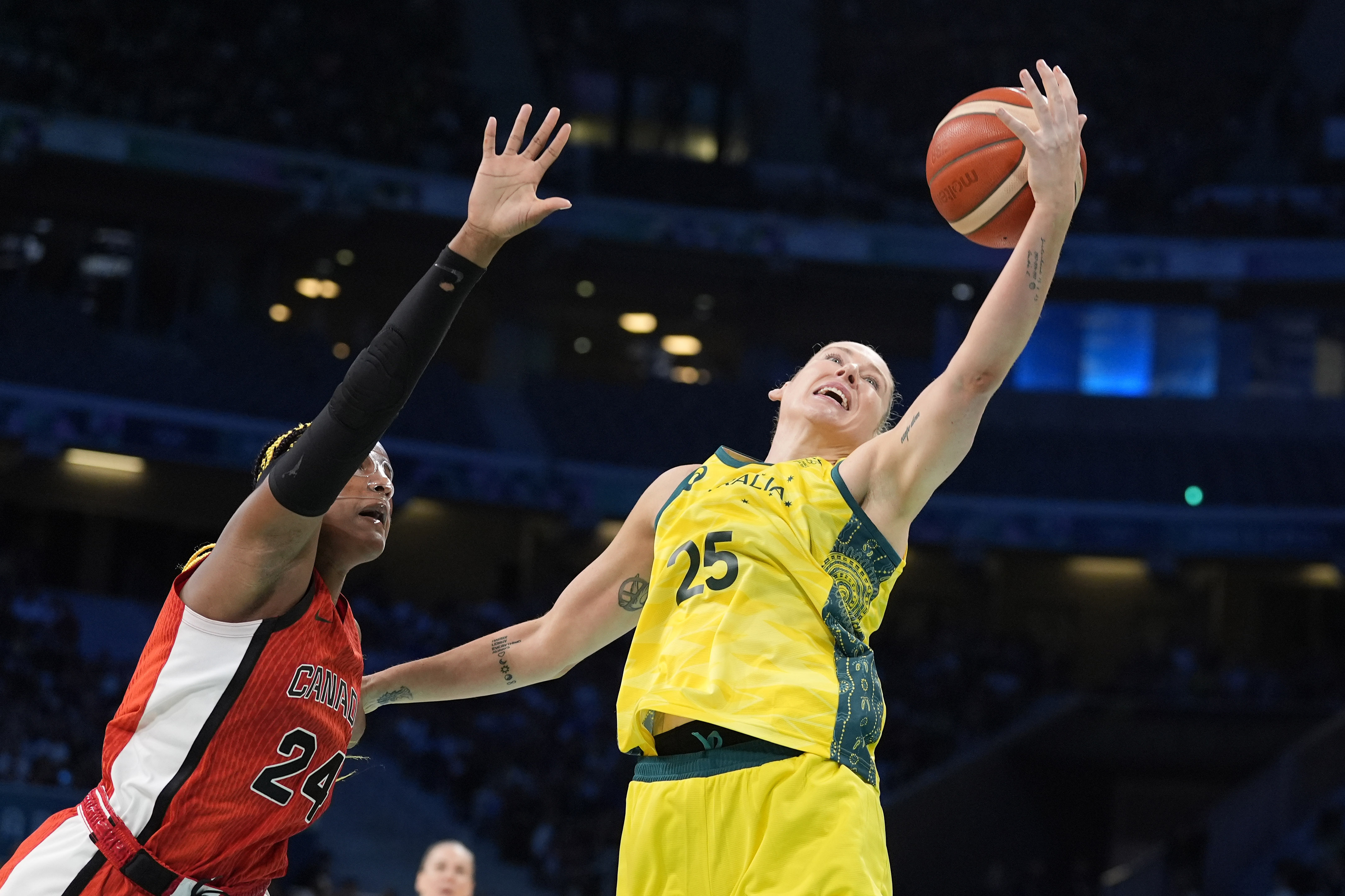 Australia's Lauren Jackson, right, reached for a rebound along with Canada's Aaliyah Edwards during a women's basketball game at the 2024 Summer Olympics, Thursday, Aug. 1, 2024, in Villeneuve-d'Ascq, France. 