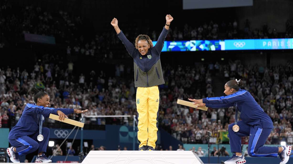 Silver medalist Simone Biles, of the United States, left, and bronze medalist Jordan Chiles, of the United States, right, bow to gold medalist Rebeca Andrade, of Brazil, during the medal ceremony for the women's artistic gymnastics individual floor finals at Bercy Arena at the 2024 Summer Olympics, Monday, Aug. 5, 2024, in Paris, France.