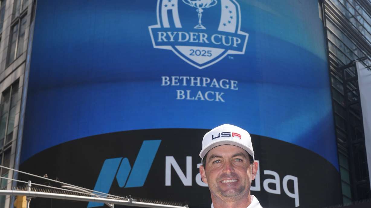 Keegan Bradley, holding a Ryder Cup trophy, poses in front of the NASDAQ building in New York, Tuesday, July 9, 2024. Bradley was introduced as the U.S. Ryder Cup captain for 2025.