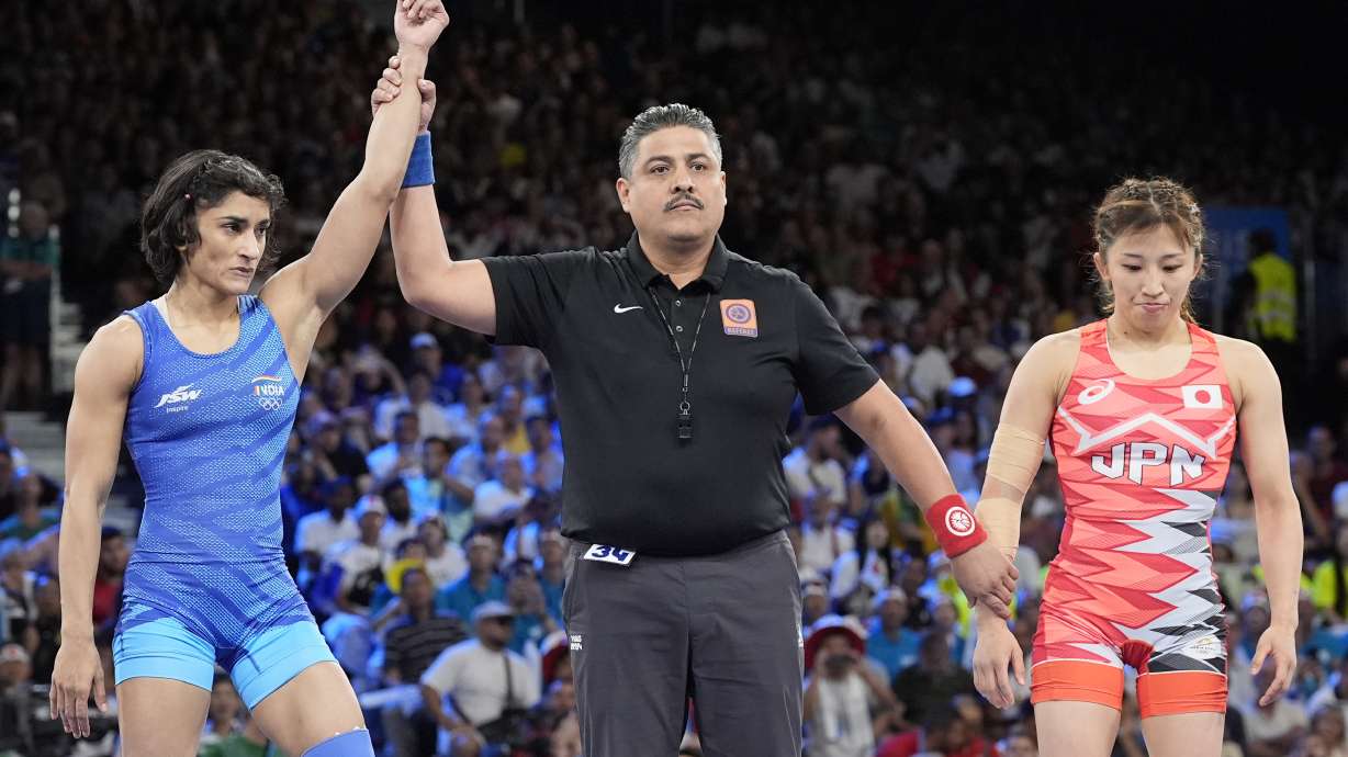 India's Vinesh Vinesh, left, celebrates after defeating Japan's Yui Susaki in the round of 16 of the women's freestyle 50kg wrestling match, at Champ-de-Mars Arena, during the 2024 Summer Olympics, Tuesday, Aug. 6, 2024, in Paris, France.