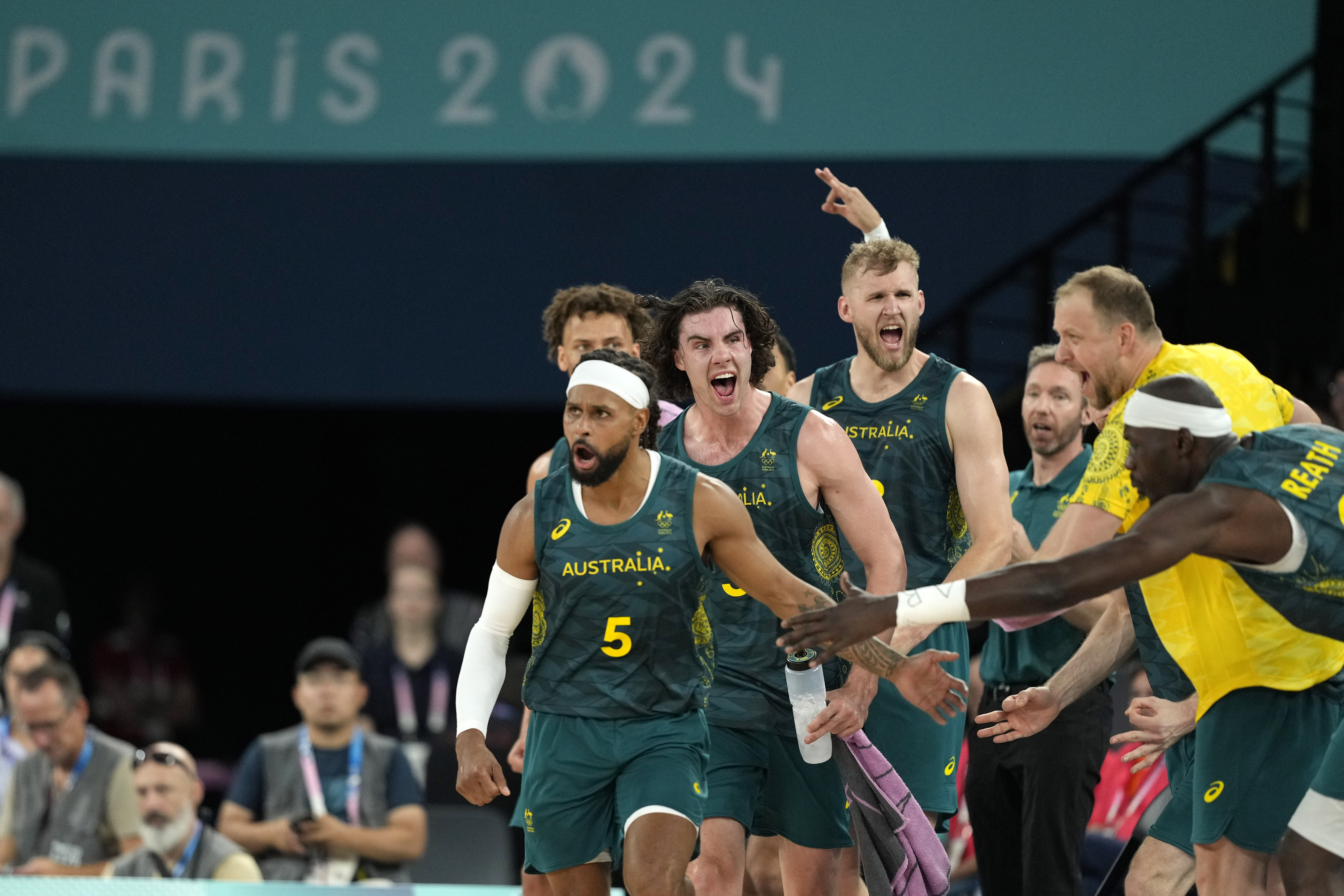 Australia'a Patty Mills, left, and other team embers celebrate after scoring during a men's quarterfinal game against Serbia at Bercy Arena at the 2024 Summer Olympics, Tuesday, Aug. 6, 2024, in Paris, France.