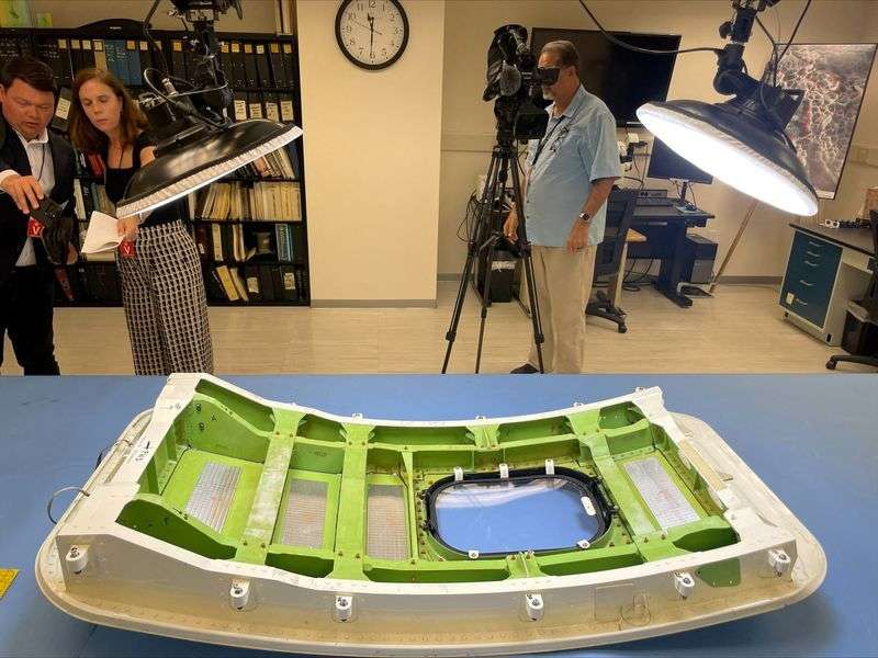 Members of the news media view the Alaska Airlines Flight 1282 door plug in advance of National Transportation Safety Board hearings in early August on the January Alaska Airlines Boeing 737 MAX 9 in-flight door plug emergency, at the NTSB materials lab in Washington, July 30.