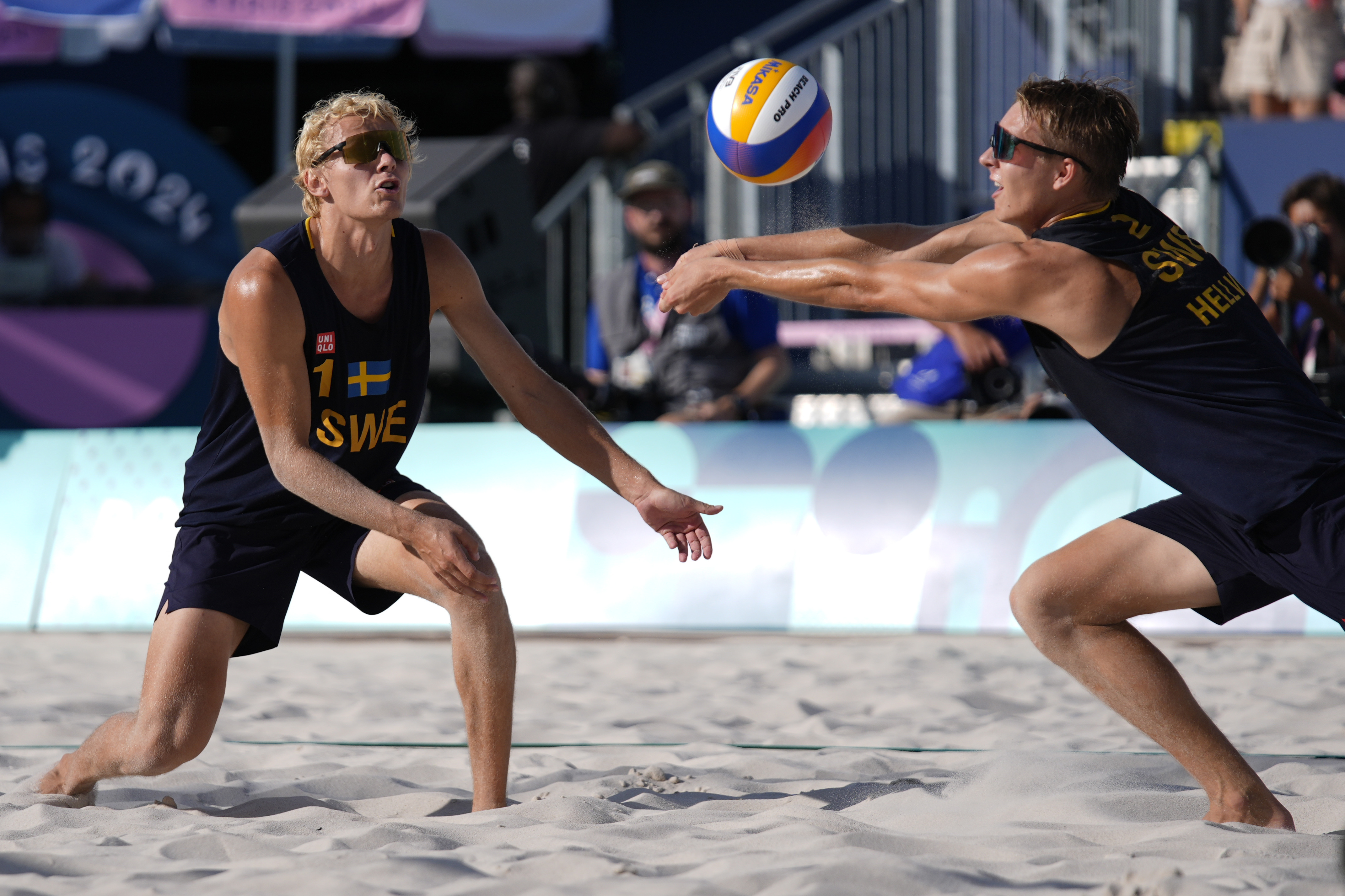 Sweden's David Ahmad, left, watches Jonatan Hellvig return a shot in a quarterfinal beach volleyball match against Brazil at the 2024 Summer Olympics, Tuesday, Aug. 6, 2024, in Paris, France. 