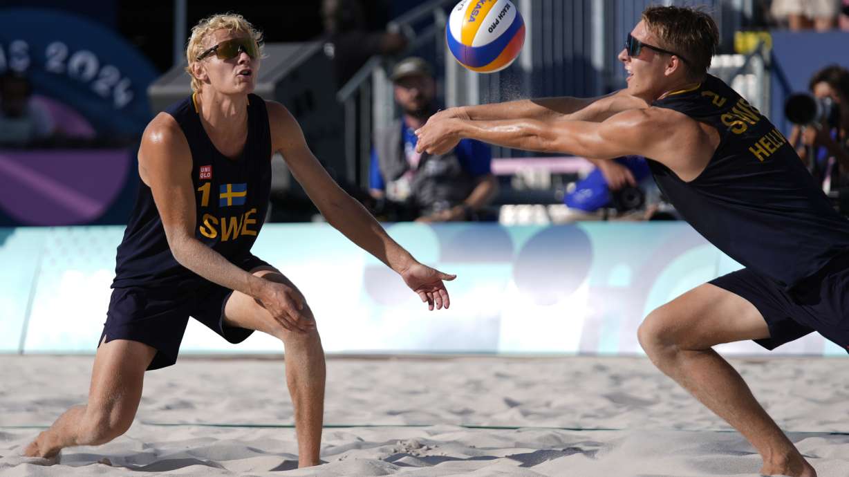 Sweden's David Ahmad, left, watches Jonatan Hellvig return a shot in a quarterfinal beach volleyball match against Brazil at the 2024 Summer Olympics, Tuesday, Aug. 6, 2024, in Paris, France.