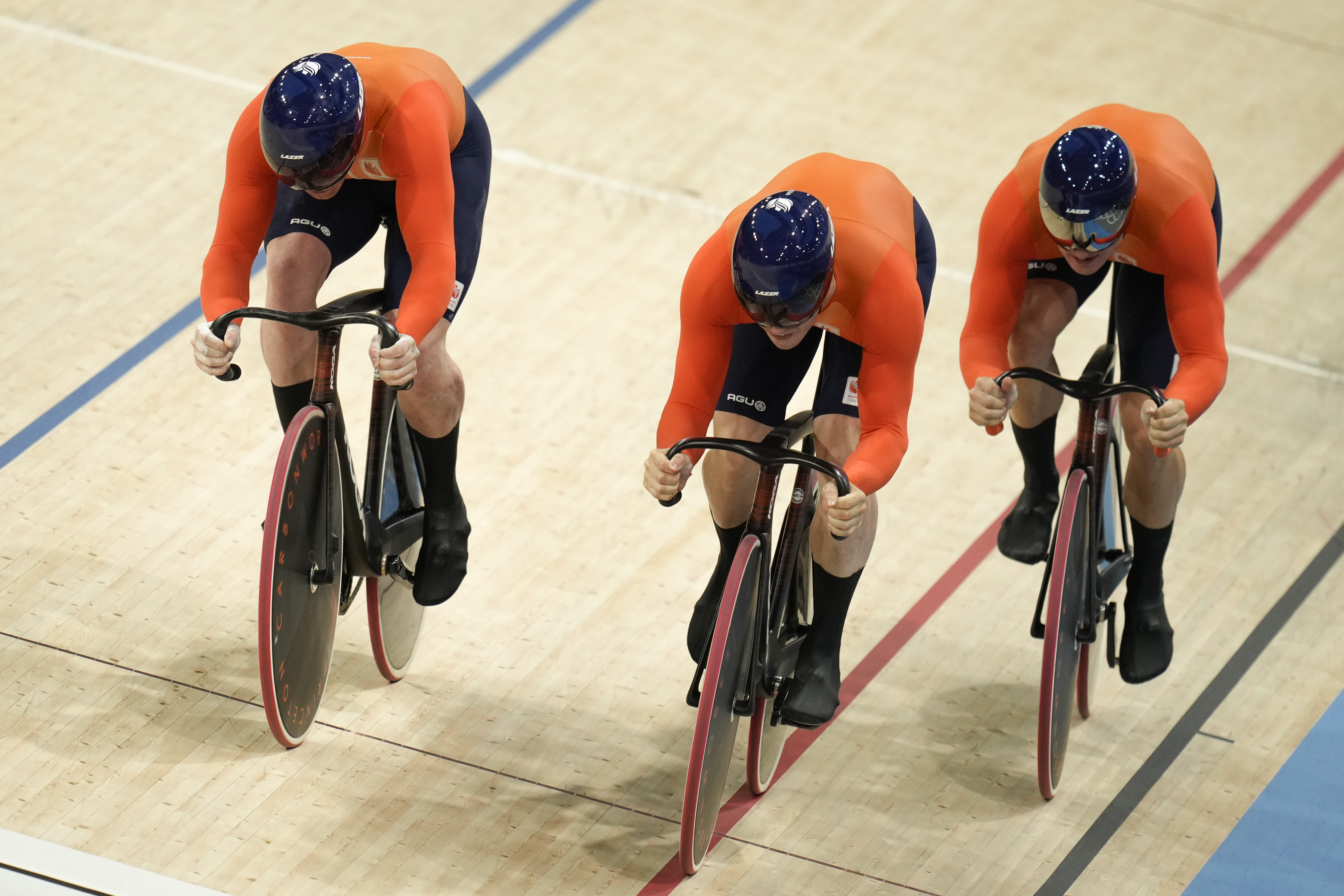 Netherlands' Roy van den Berg, Harrie Lavreysen and Jeffrey Hoogland cross the finish line and set the new world record during the men's team sprint event, at the Summer Olympics, Tuesday, Aug. 6, 2024, in Paris, France. 