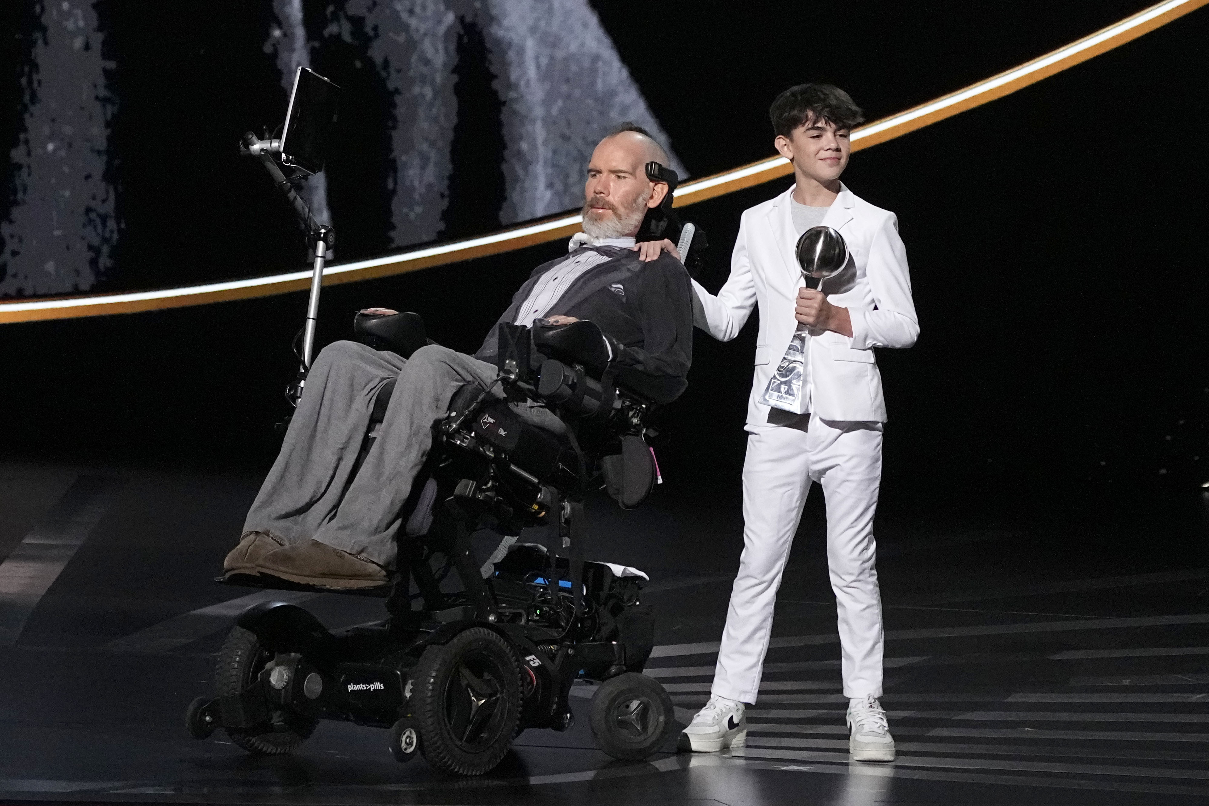 Steve Gleason, left, recieves the Arthur Ashe Award for Courage, held by his son Rivers, right, at the ESPY awards on Thursday, July 11, 2024, at the Dolby Theatre in Los Angeles. 
