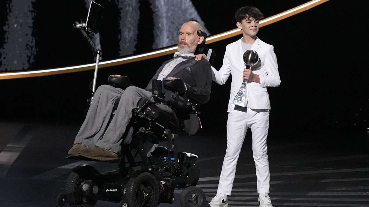 Steve Gleason, left, recieves the Arthur Ashe Award for Courage, held by his son Rivers, right, at the ESPY awards on Thursday, July 11, 2024, at the Dolby Theatre in Los Angeles.