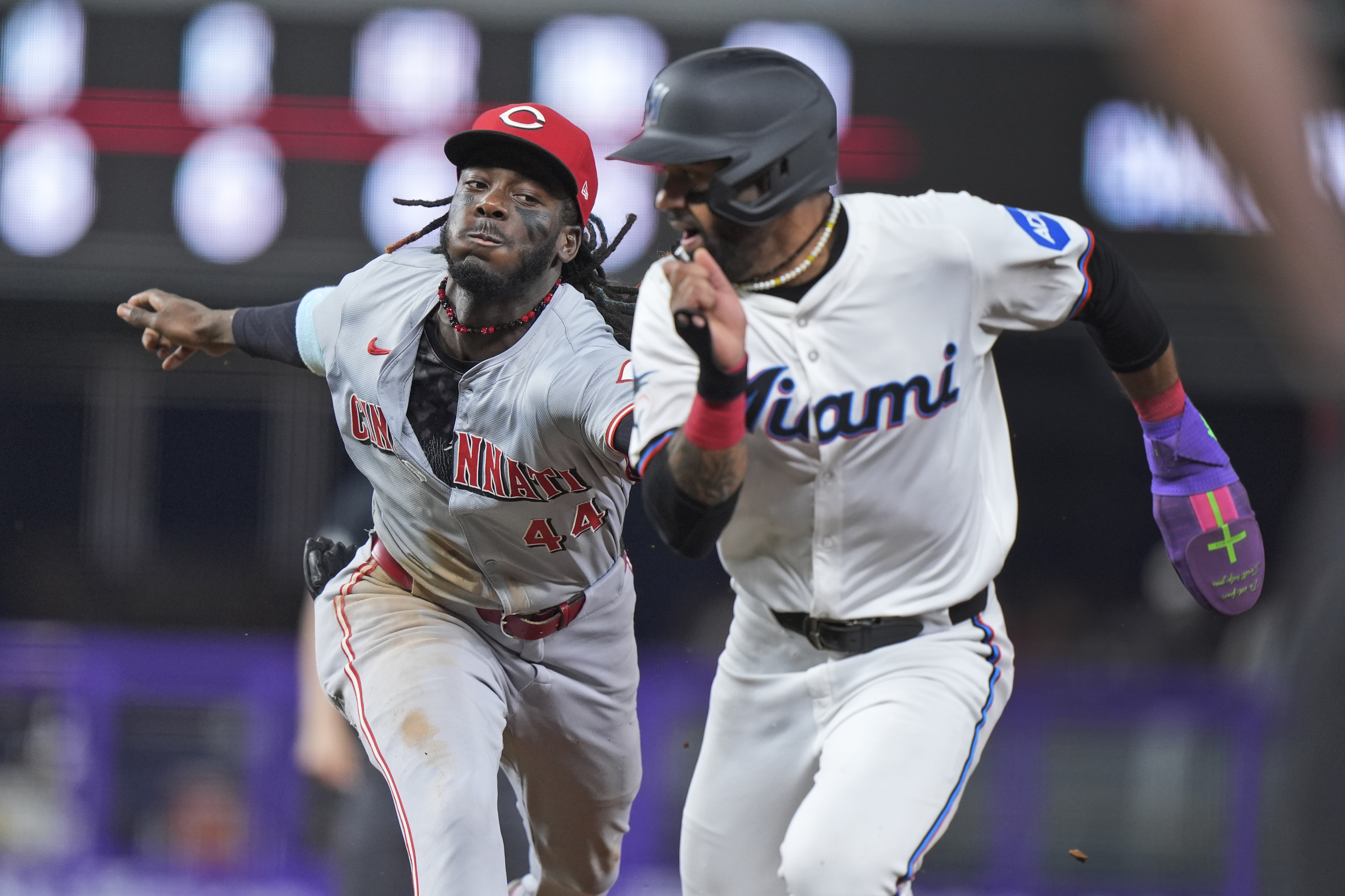 Cincinnati Reds shortstop Elly De La Cruz (44) runs down and tags out Miami Marlins' Derek Hill, after Hill was caught attempting to steal second base during the fourth inning of a baseball game, Tuesday, Aug. 6, 2024, in Miami. 
