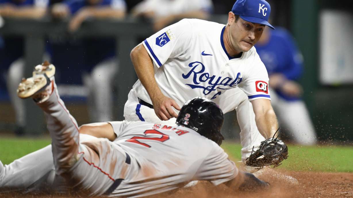 Boston Red Sox's Dominic Smith (2) beats the tag by Kansas City Royals starting pitcher Seth Lugo to score during the sixth inning of a baseball game, Tuesday, Aug. 6, 2024, in Kansas City, Mo.