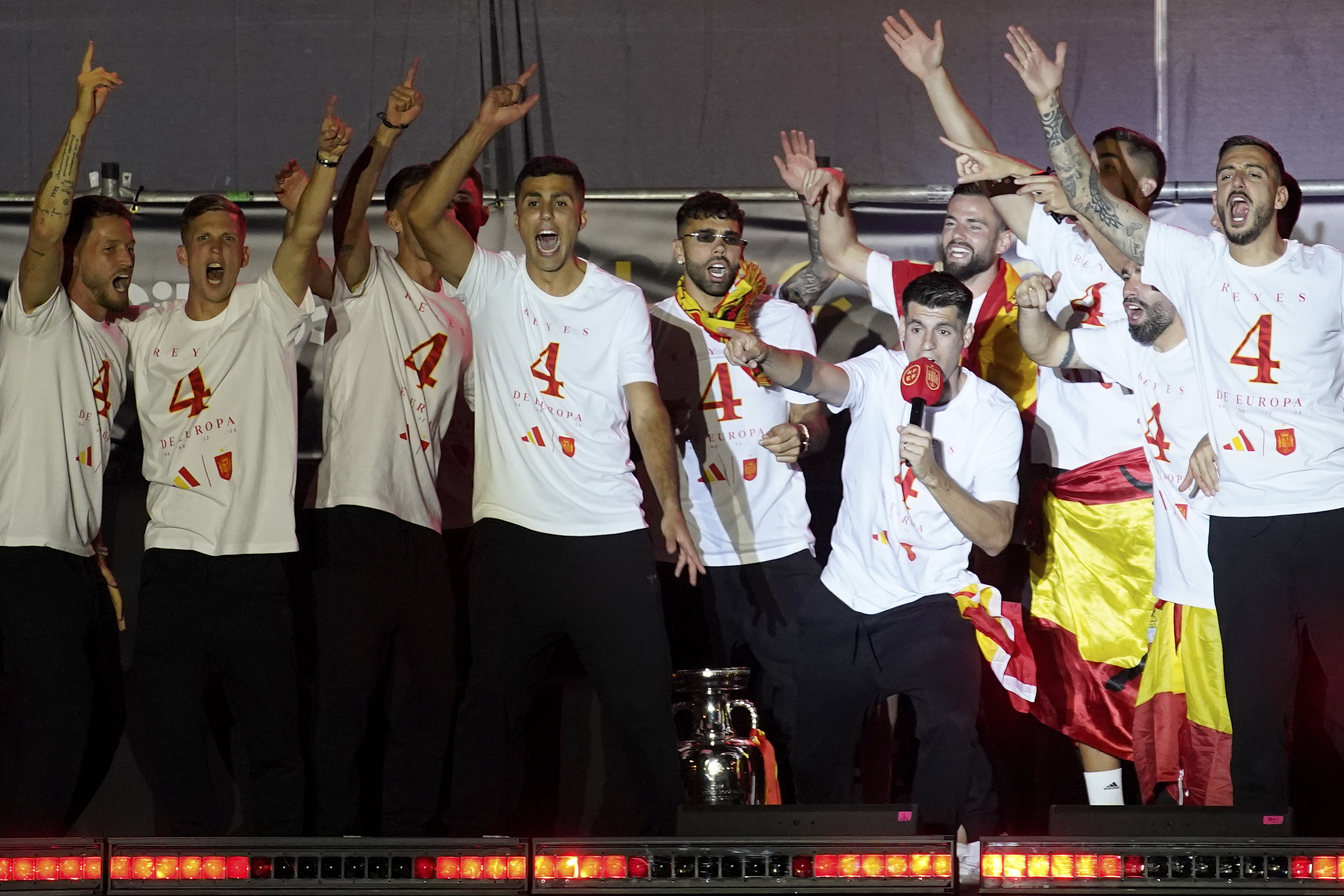 Spain's team captain Alvaro Morata, with the microphone, introduces player Rodri, center, to the fans during celebrations of the Spanish team's European soccer championship title on a stage at Cibeles square in Madrid, Monday, July 15, 2024. Spain defeated England in the final of the Euro 2024 soccer tournament in Berlin on Sunday evening. 