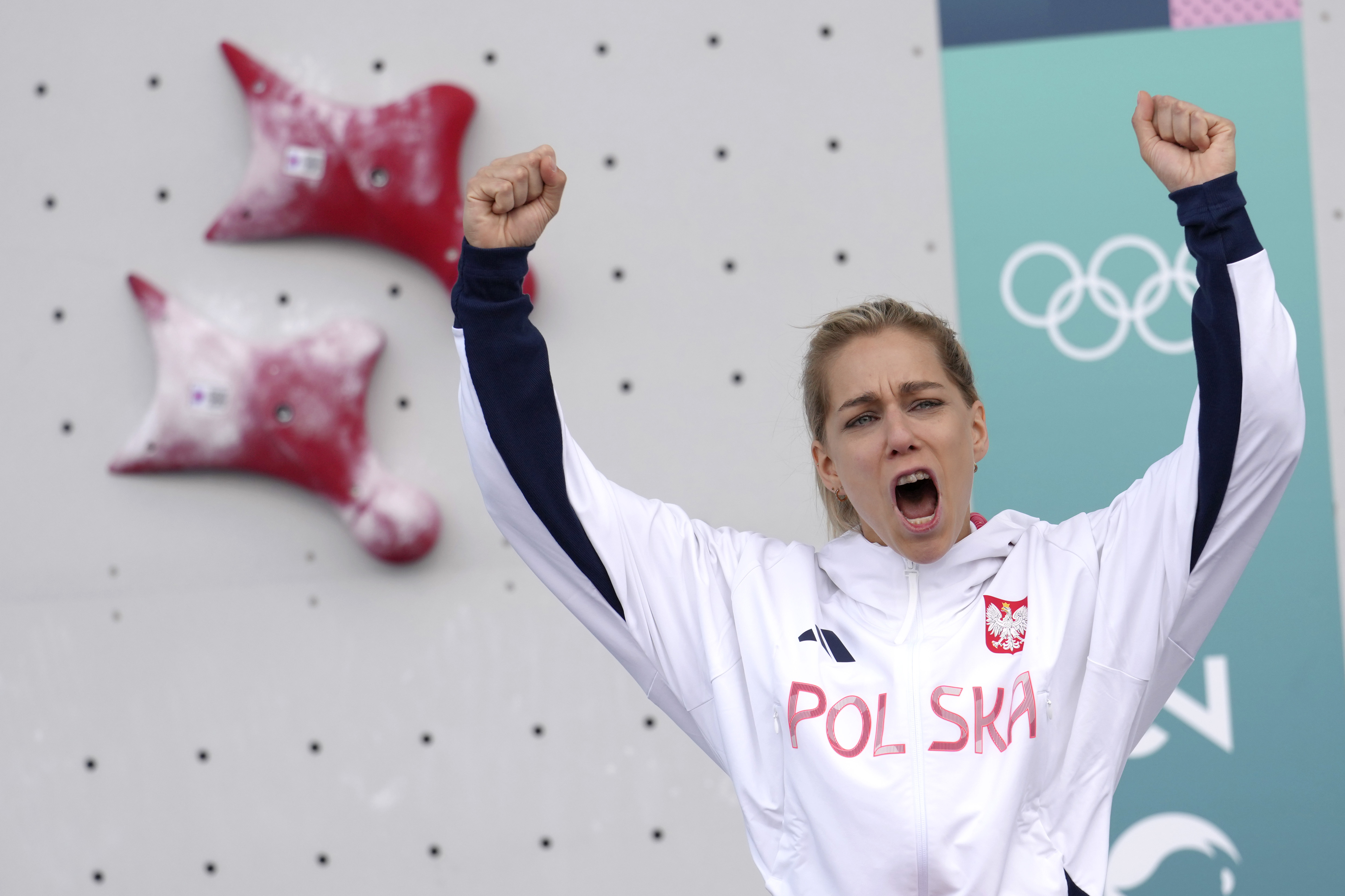 Gold medallist Aleksandra Miroslaw of Poland celebrates on the podium after winnin the women's speed final during the sport climbing competition at the 2024 Summer Olympics, Wednesday, Aug. 7, 2024, in Le Bourget, France.